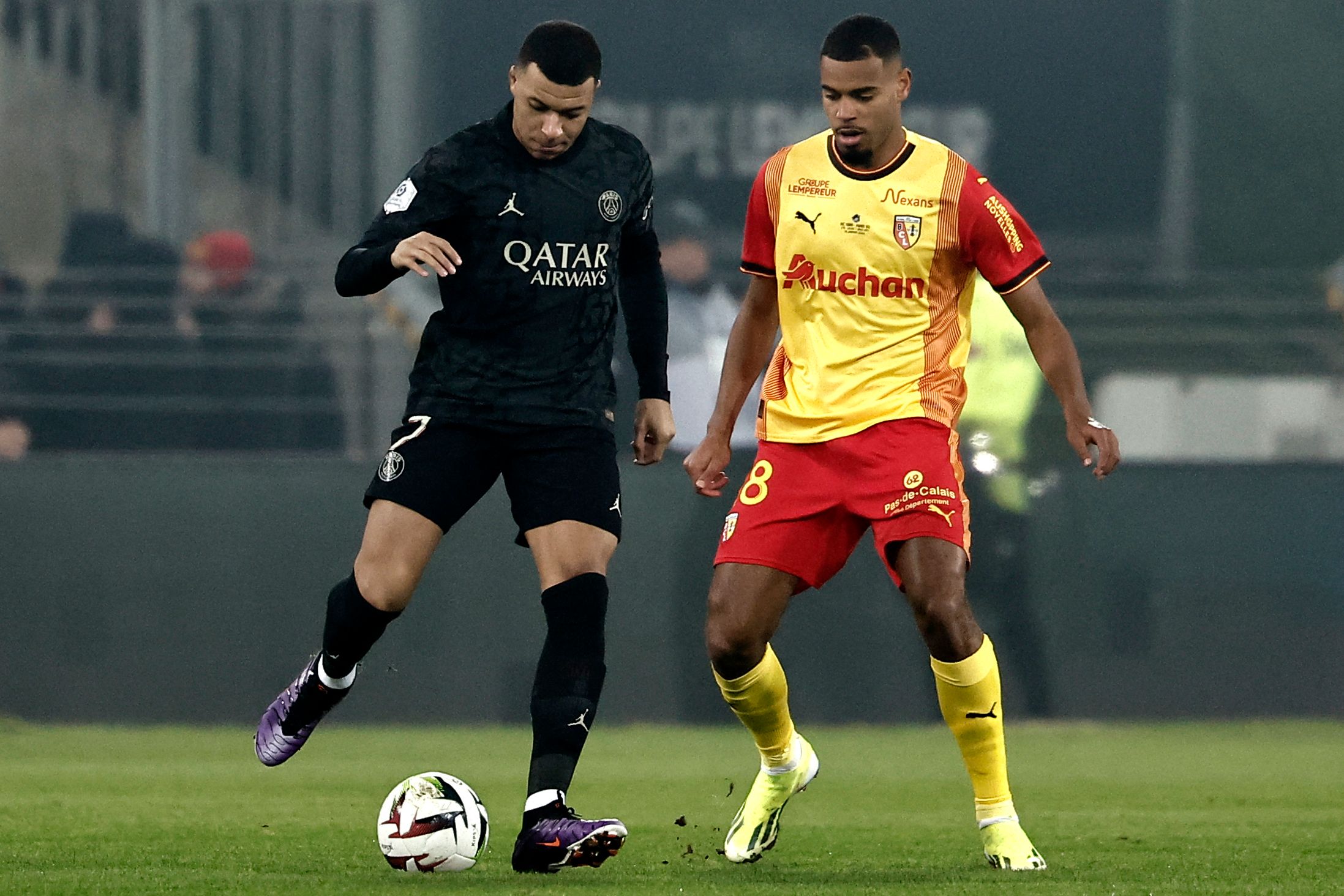 Paris Saint-Germain's French forward #07 Kylian Mbappe (L) fights for the ball with Lens' French midfielder #18 Andy Diouf (R) during the French L1 football match between RC Lens and Paris Saint-Germain (PSG) at Stade Bollaert-Delelis in Lens, northern France on January 14, 2024. (Photo by Sameer Al-Doumy / AFP)
