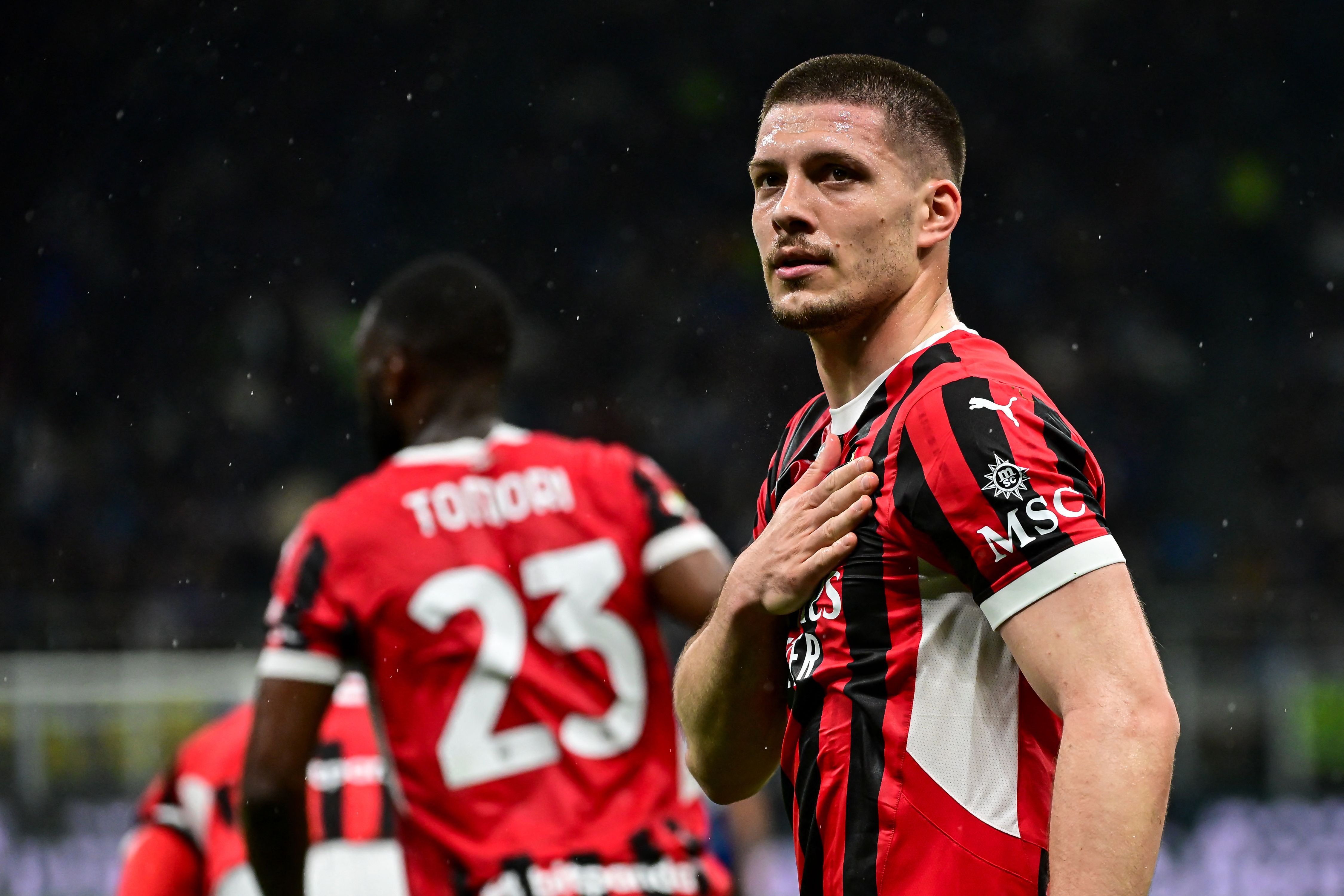 AC Milan's Serbian forward #09 Luka Jovic (R) celebrates after scoring AC Milan's first goal during the Coppa Italia second leg semi-final football match between Inter Milan and AC Milan at the San Siro stadium in Milan on April 23, 2025. (Photo by Piero CRUCIATTI / AFP)
