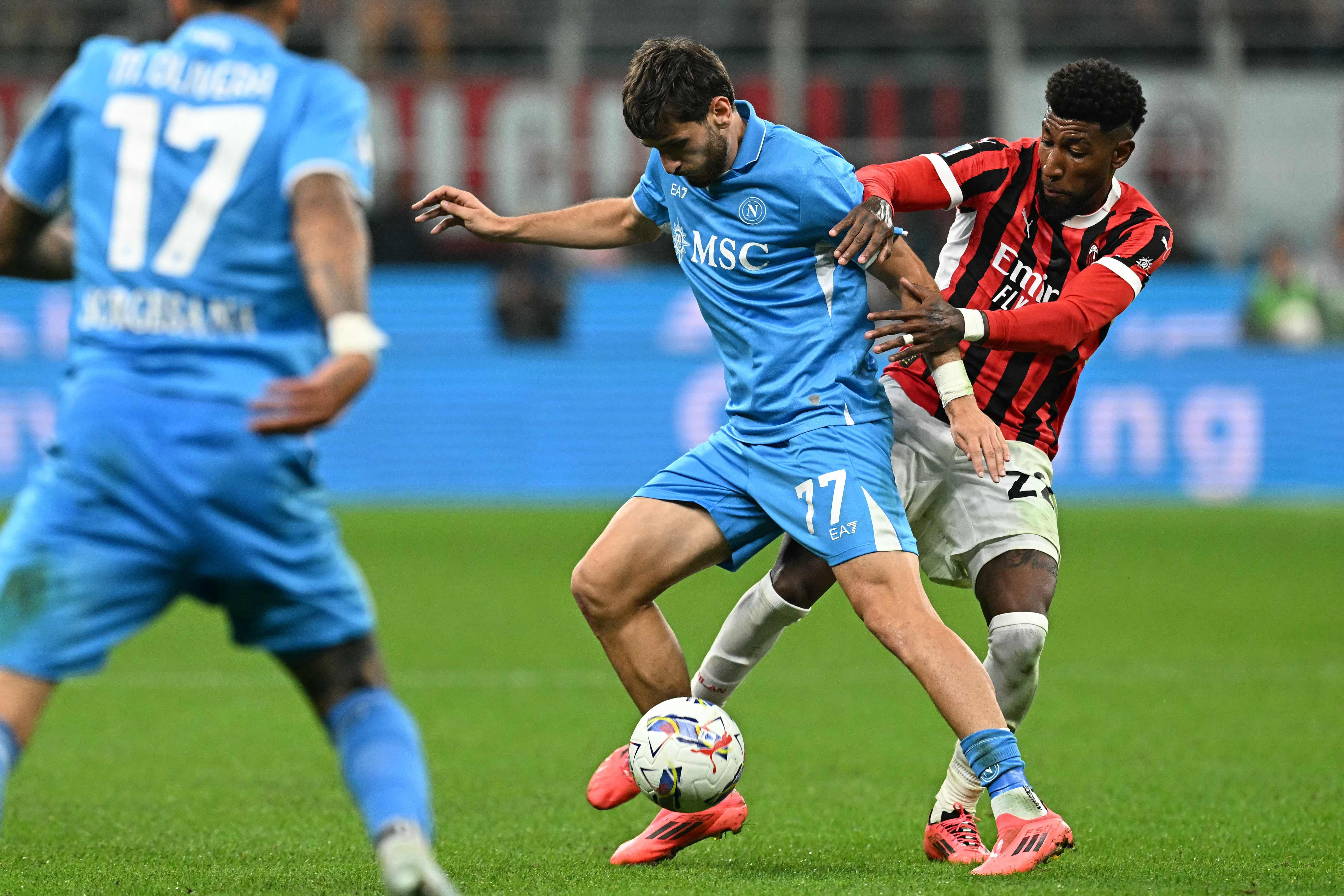 Napoli's Georgian forward #77 Khvicha Kvaratskhelia (C) fihts for the ball with AC Milan's Brazilian defender #22 Emerson Royal during the Italian Serie A football match Ac Milan vs Napoli at San Siro Meazza stadium in Milan on October 29, 2024. (Photo by Gabriel BOUYS / AFP)