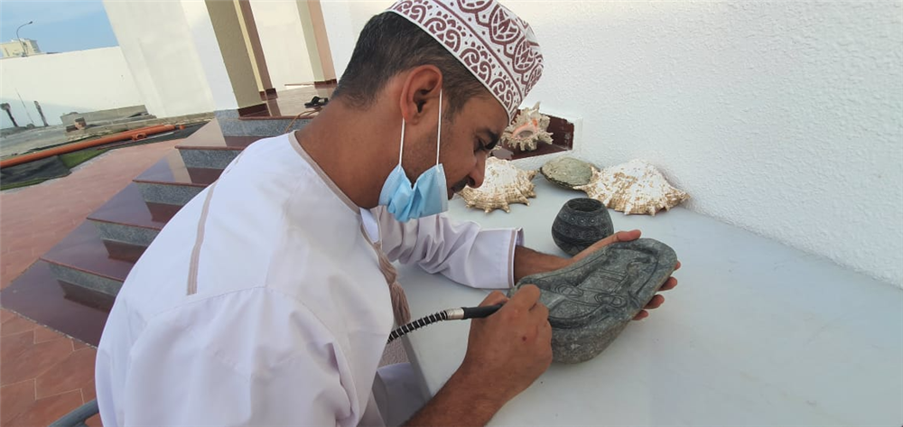 مواطن ينحت الصخور الموجودة في الطبيعة العمانية