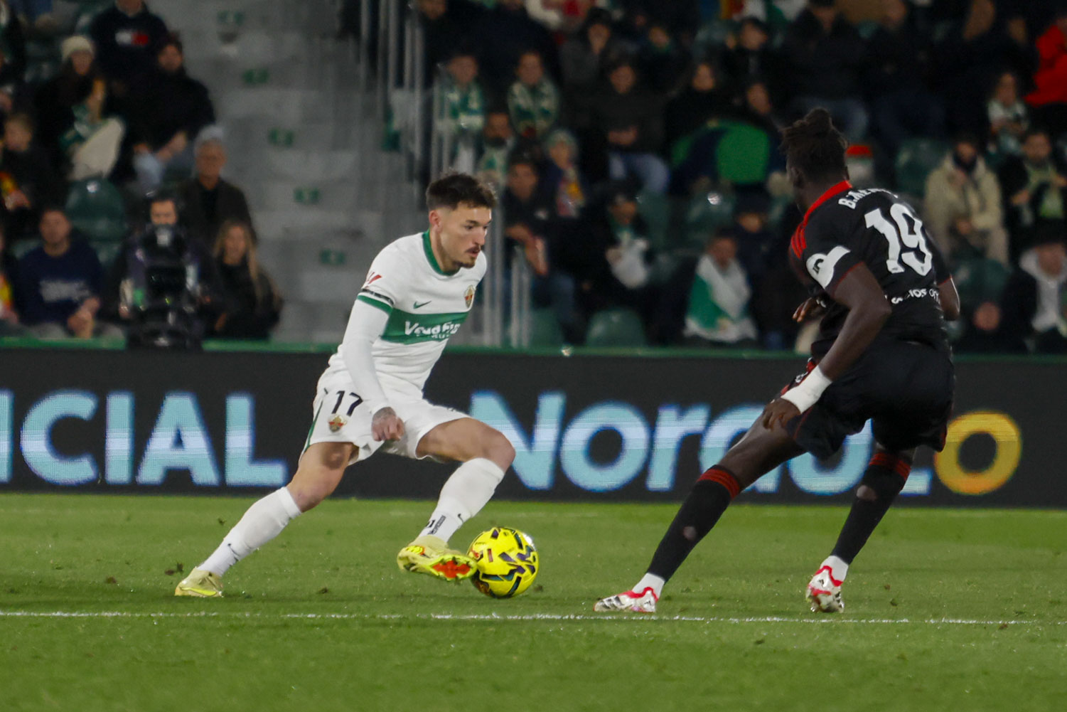 ELCHE (ALICANTE), 19/01/2026.- El centrocampista del Elche Josan Fernández (i) juega un balón ante Batista Mendy, del Sevilla, durante el partido de LaLiga EA Sports que Elche CF y Sevilla FC disputan este lunes en el estadio Martínez Valero. EFE/Pablo Miranzo
