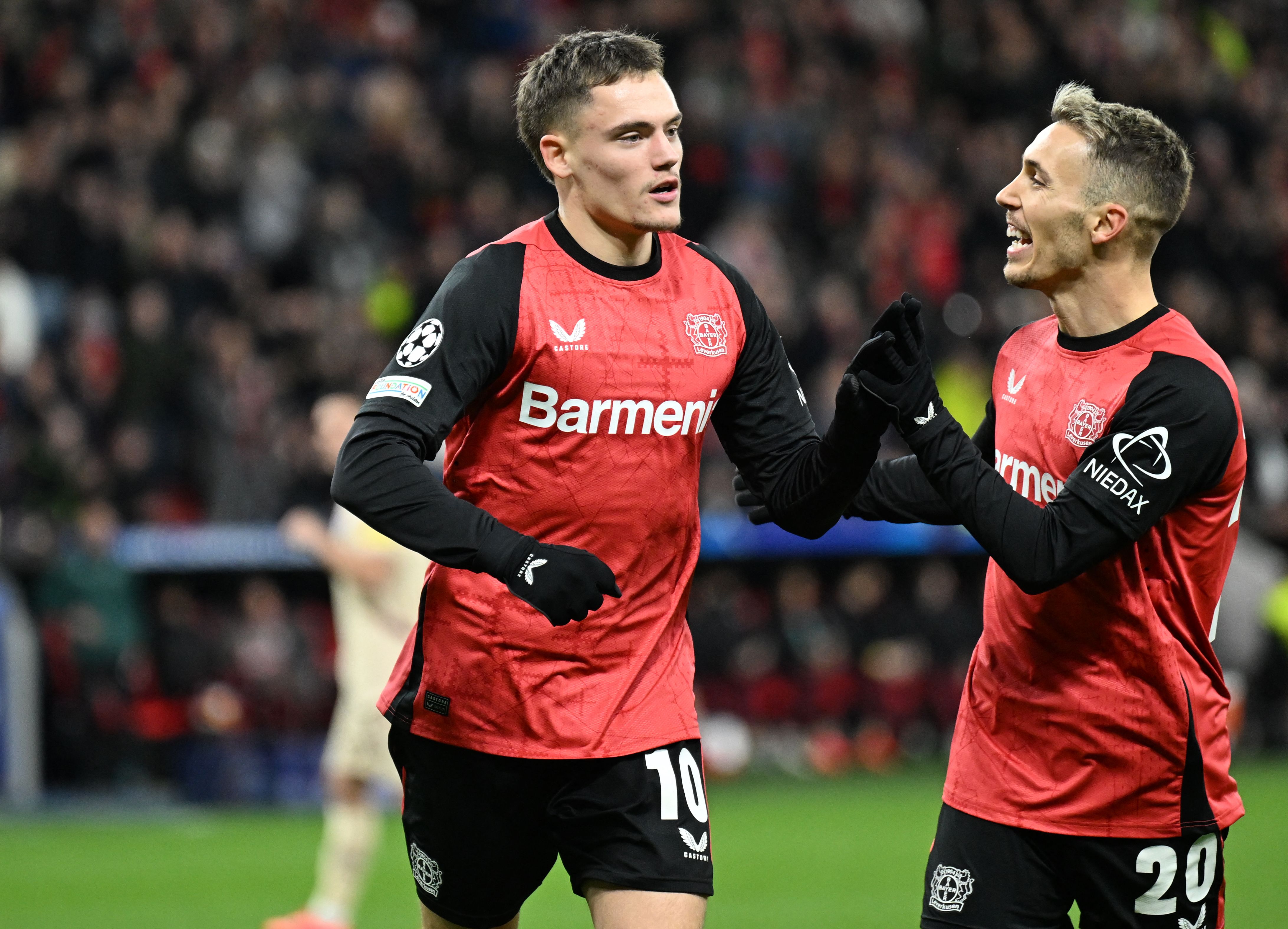 Bayer Leverkusen's German midfielder #10 Florian Wirtz (L) celebrates scoring his team's first goal with Bayer Leverkusen's Spanish defender #20 Alejandro Grimaldo during the UEFA Champions League football match Bayer 04 Leverkusen vs FC Salzburg in Leverkusen, western Germany on November 26, 2024. (Photo by INA FASSBENDER / AFP)