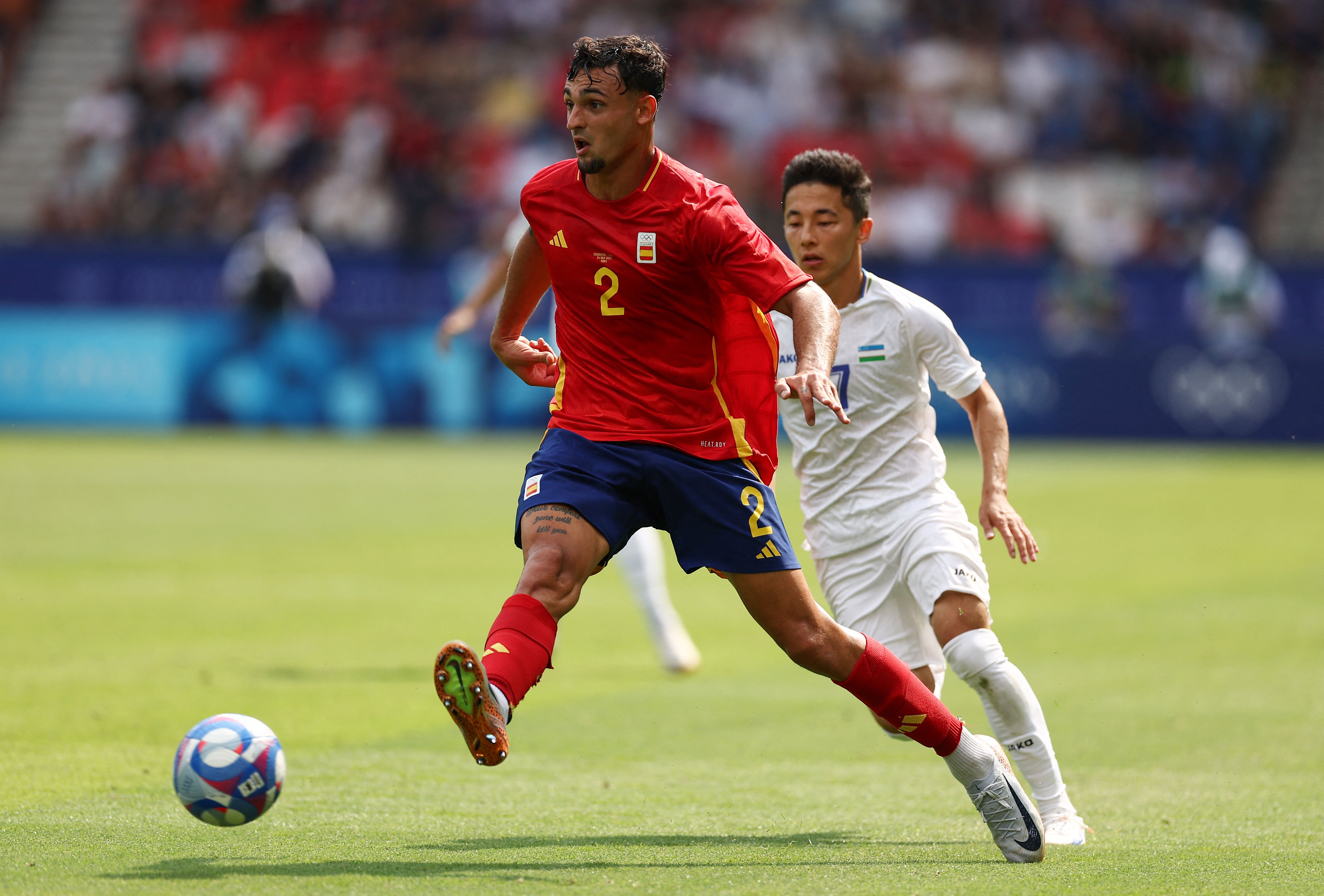 Spain's defender #02 Marc Pubill (L) fights for the ball with Uzbekistan's midfielder #07 Abbosbek Fayzullaev  during the men's group C football match between Uzbekistan and Spain of the the Paris 2024 Olympic Games at the Parc des Princes in Paris on July 24, 2024. (Photo by FRANCK FIFE / AFP)