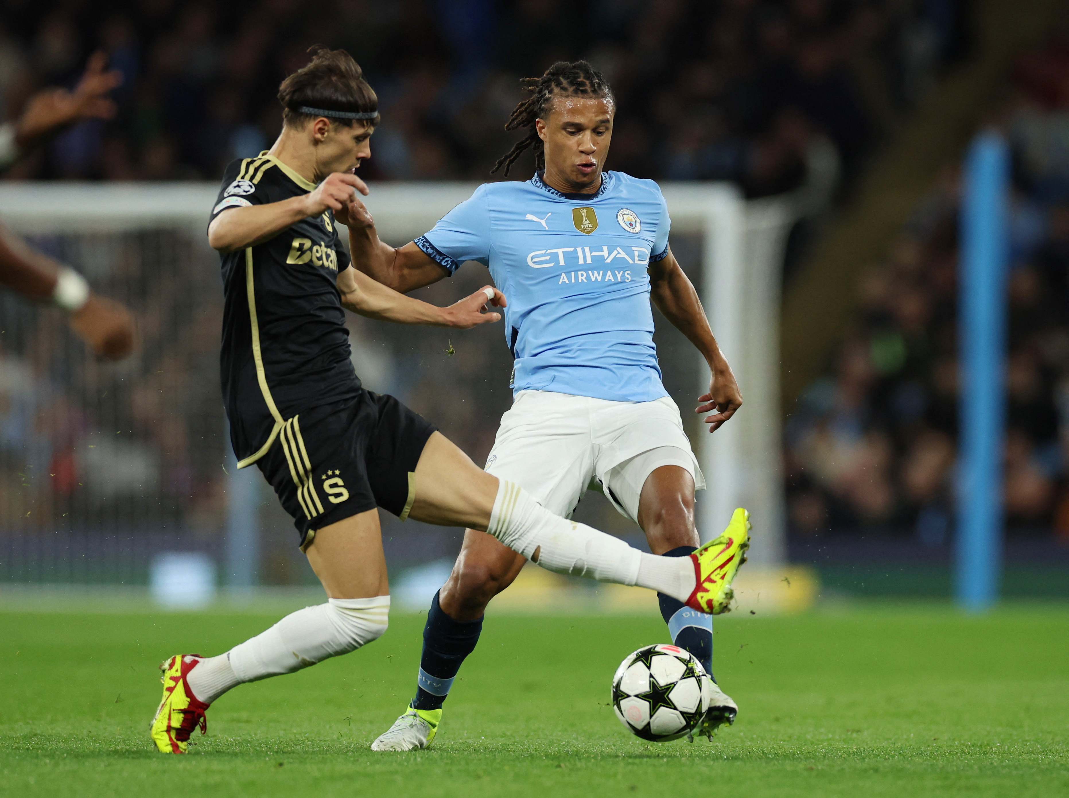 Soccer Football - Champions League - Manchester City v Sparta Prague - Etihad Stadium, Manchester, Britain - October 23, 2024 Manchester City's Nathan Ake in action with Sparta Prague's Veljko Birmancevic REUTERS/Phil Noble