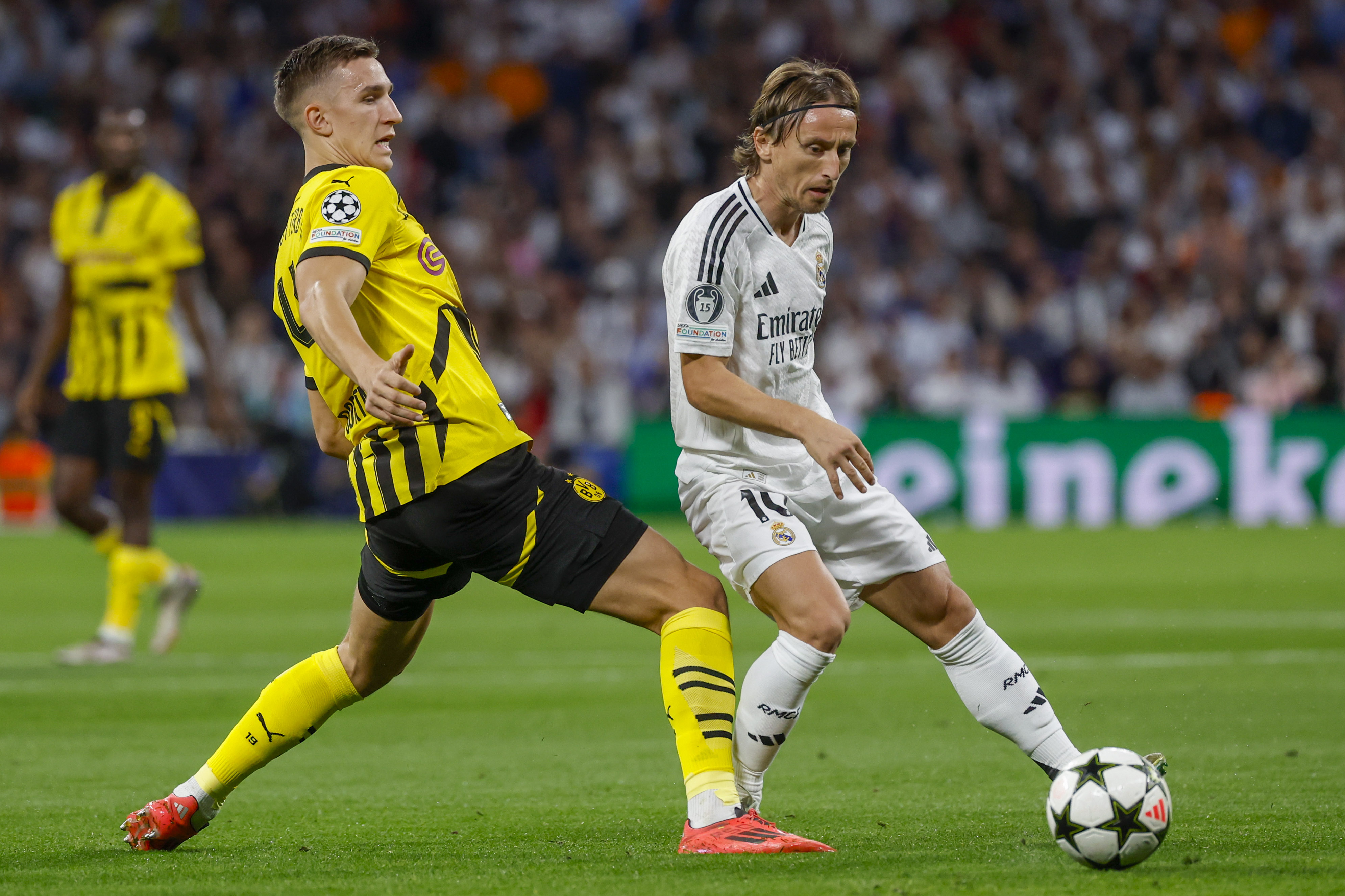 MADRID, 22/10/2024.- El centrocampista croata del Real Madrid Luka Modric (d) disputa un balón con el defensa alemán del Borussia Nico Schlotterbeck (i) durante el encuentro correspondiente a la fase regular de la Liga de Campeones entre Real Madrid y Borussia Dortmund, este martes en el estadio Santiago Bernabéu, en Madrid. EFE / Juanjo Martín
