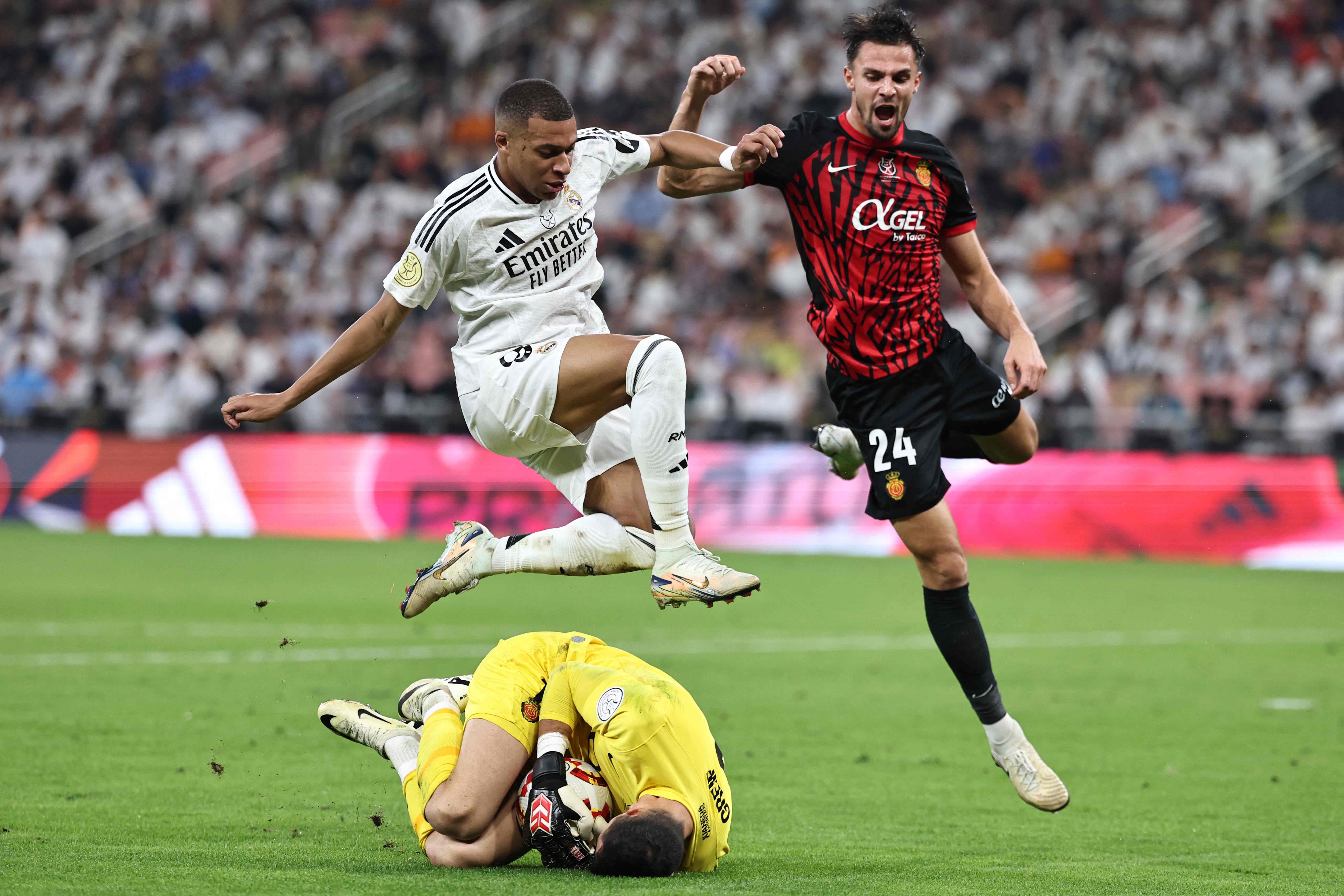 Real Mallorca's Slovak goalkeeper #1 Dominik Greif gathers the ball ahead of Real Madrid's French forward #9 Kylian Mbappe during the Spanish Super Cup semi-final football match between Real Madrid and Mallorca at the King Abdullah Sport City in Jeddah on January 9, 2025. (Photo by FADEL SENNA / AFP)