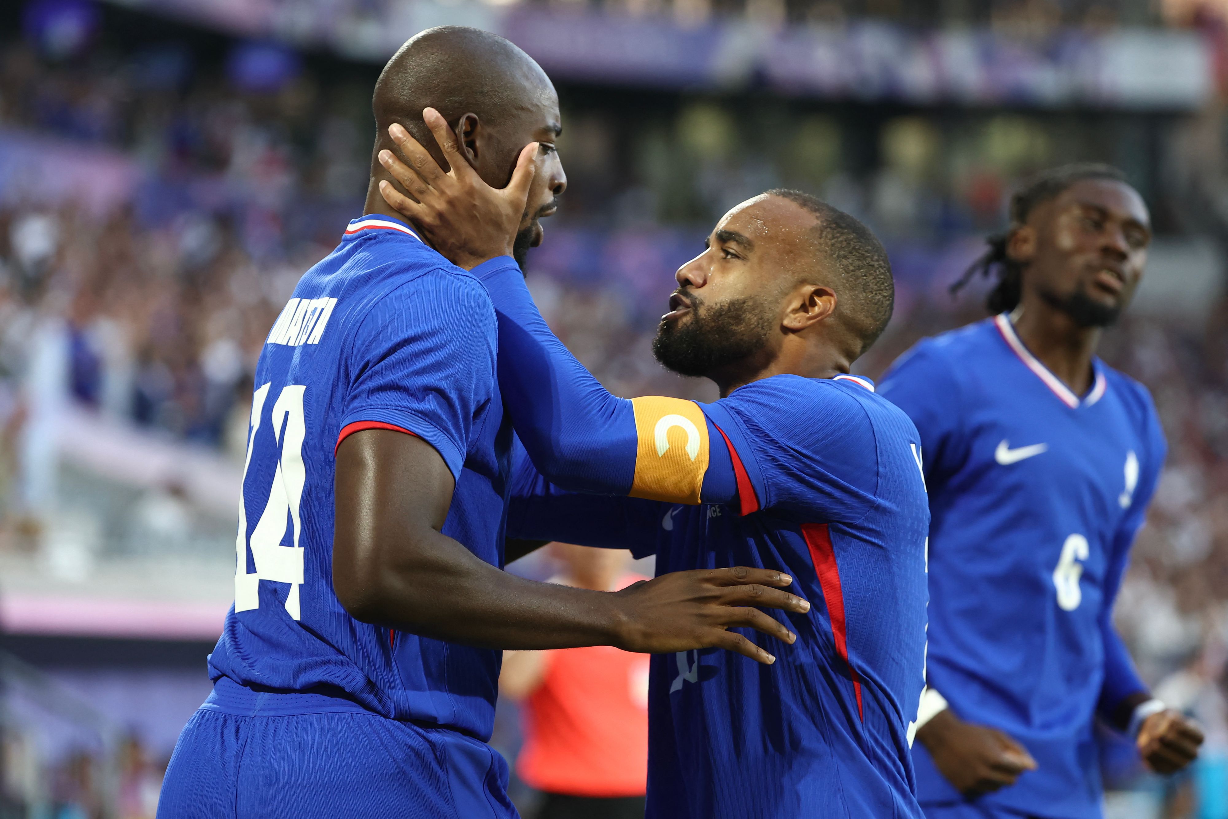 France's forward #14 Jean-Philippe Mateta (L) celebrates with France's forward #10 Alexandre Lacazette after scoring his team's first goal in the men's quarter-final football match between France and Argentina during the Paris 2024 Olympic Games at the Bordeaux Stadium in Bordeaux on August 2, 2024. (Photo by ROMAIN PERROCHEAU / AFP)