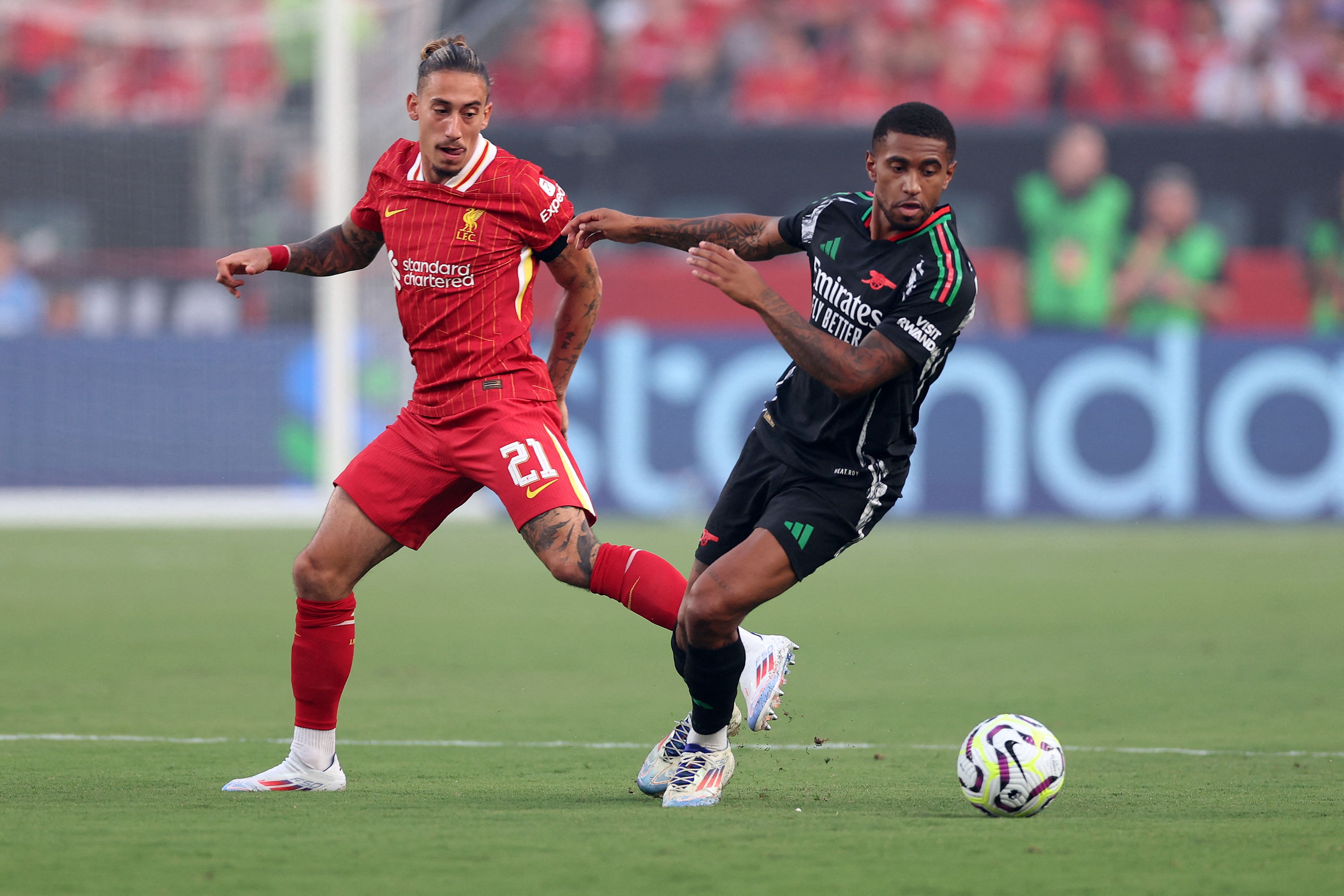 Liverpool's Greek defender #21 Konstantinos Tsimikas (L) fights for the ball with Arsenal's English forward #24 Reiss Nelson (R) during the pre-season club friendly football match between Arsenal FC and Liverpool FC at Lincoln Financial Field in Philadelphia, Pennsylvania, on July 31, 2024. (Photo by CHARLY TRIBALLEAU / AFP)