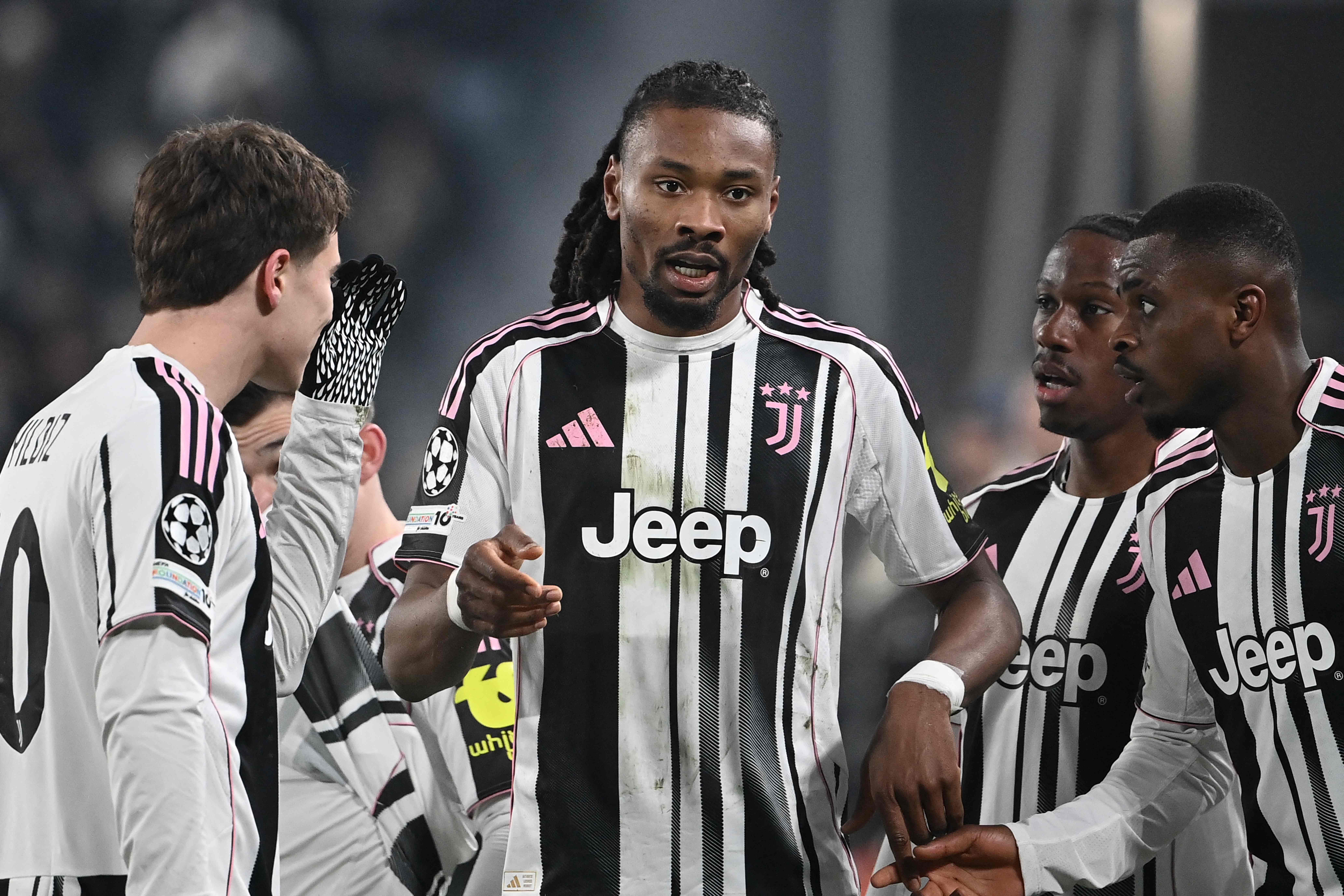 Juventus' French midfielder #19 Khephren Thuram-Ulien (C) celebrates scoring his team's first goal with Juventus' Turkish forward #10 Kenan Yildiz (L) and Juventus' French defender #15 Pierre Kalulu Kyatengwa (R) during the UEFA Champions League - league phase day 7 football match between Juventus and Benfica at the Allianz stadium in Turin, on January 21, 2026. (Photo by Isabella BONOTTO / AFP)
