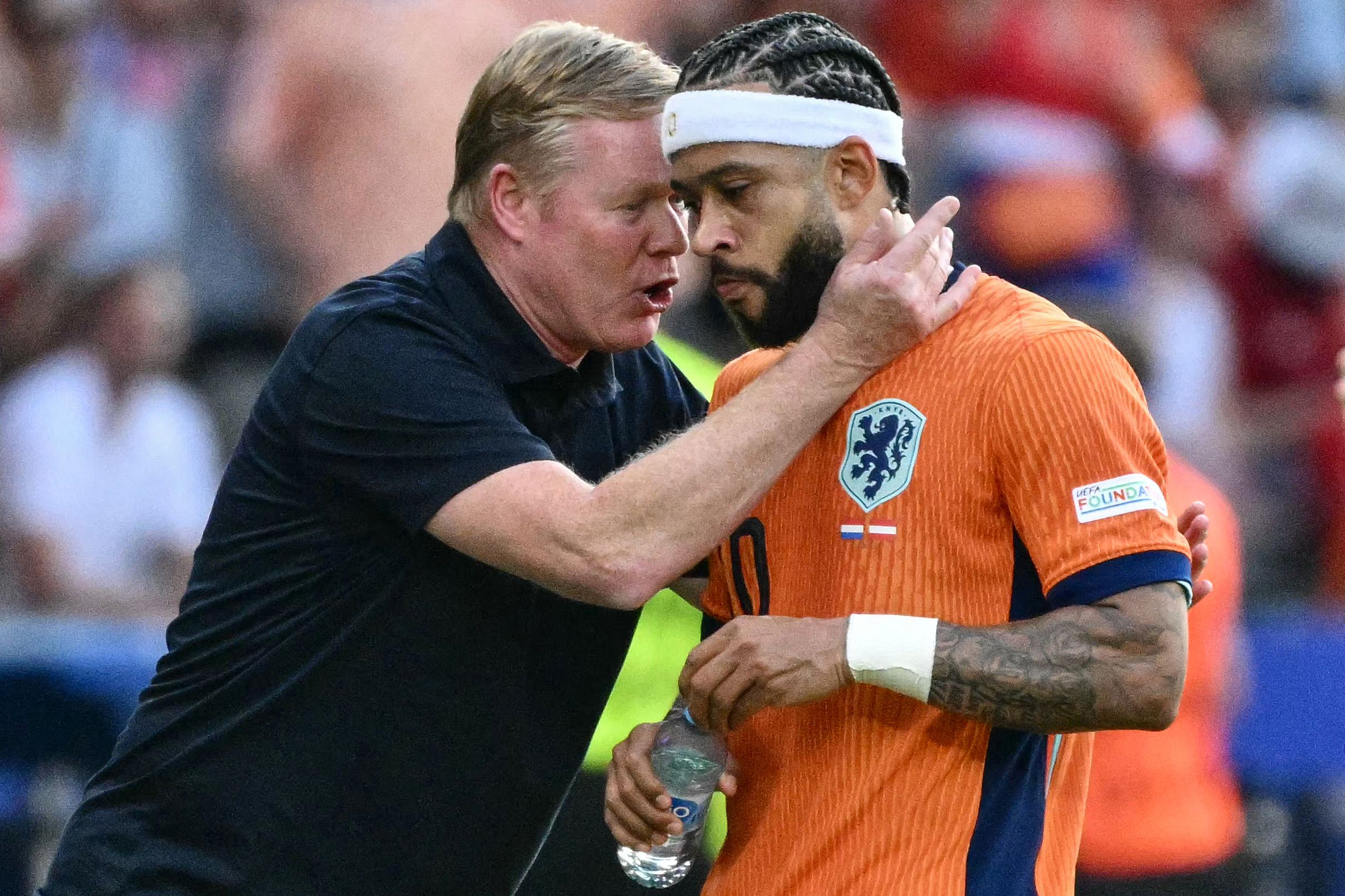 Netherlands' forward #10 Memphis Depay is congratulated by his head coach Ronald Koeman after scoring his team's second goal during the UEFA Euro 2024 Group D football match between the Netherlands and Austria at the Olympiastadion in Berlin on June 25, 2024. (Photo by Christophe SIMON / AFP)