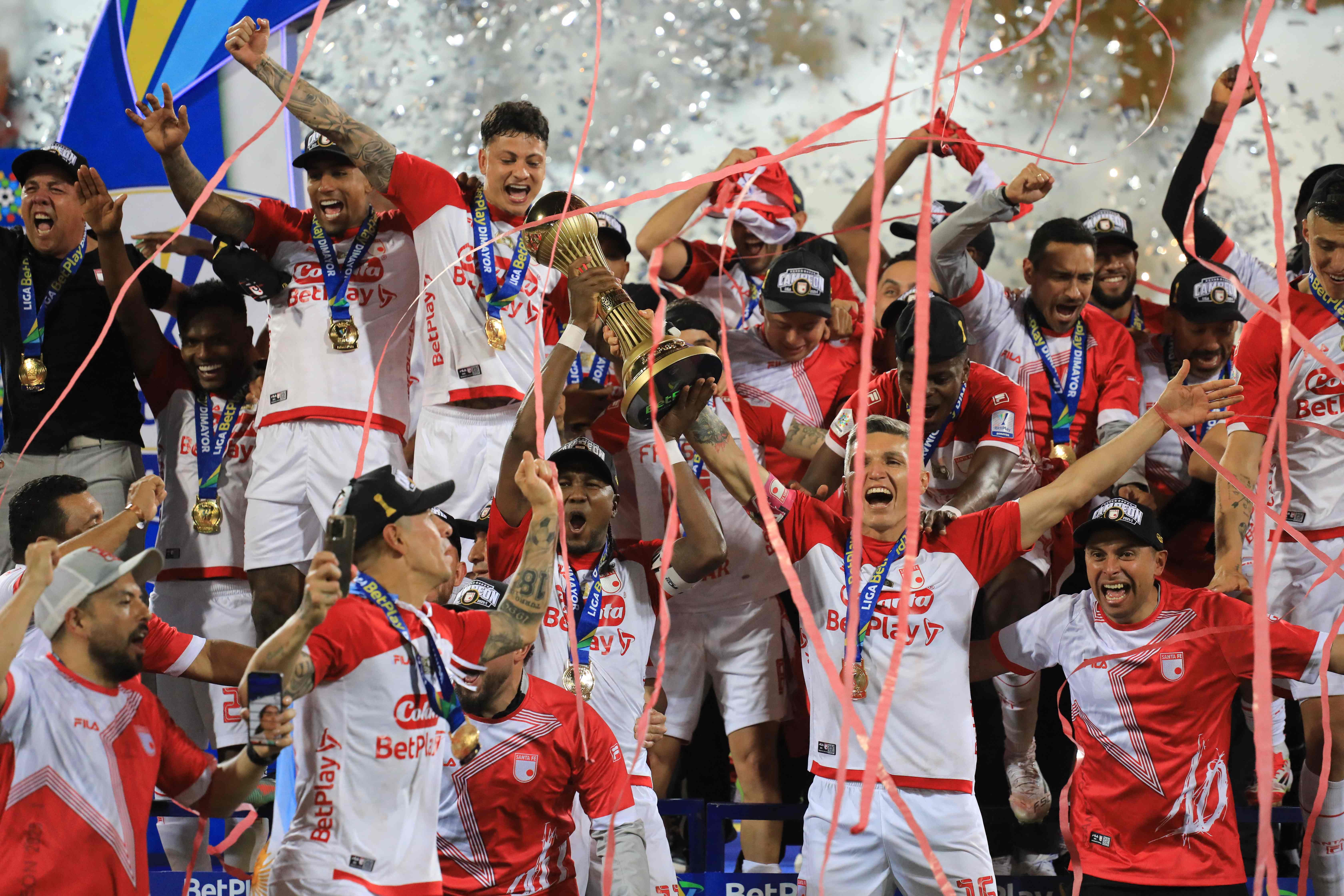 Independiente Santa Fe players celebrate with the trophy after winning the Colombian football championship final match between Independiente Medellin and Independiente Santa Fe at the Atanasio Girardot Stadium in Medellin, Colombia, on June 29, 2025. (Photo by JAIME SALDARRIAGA / AFP)