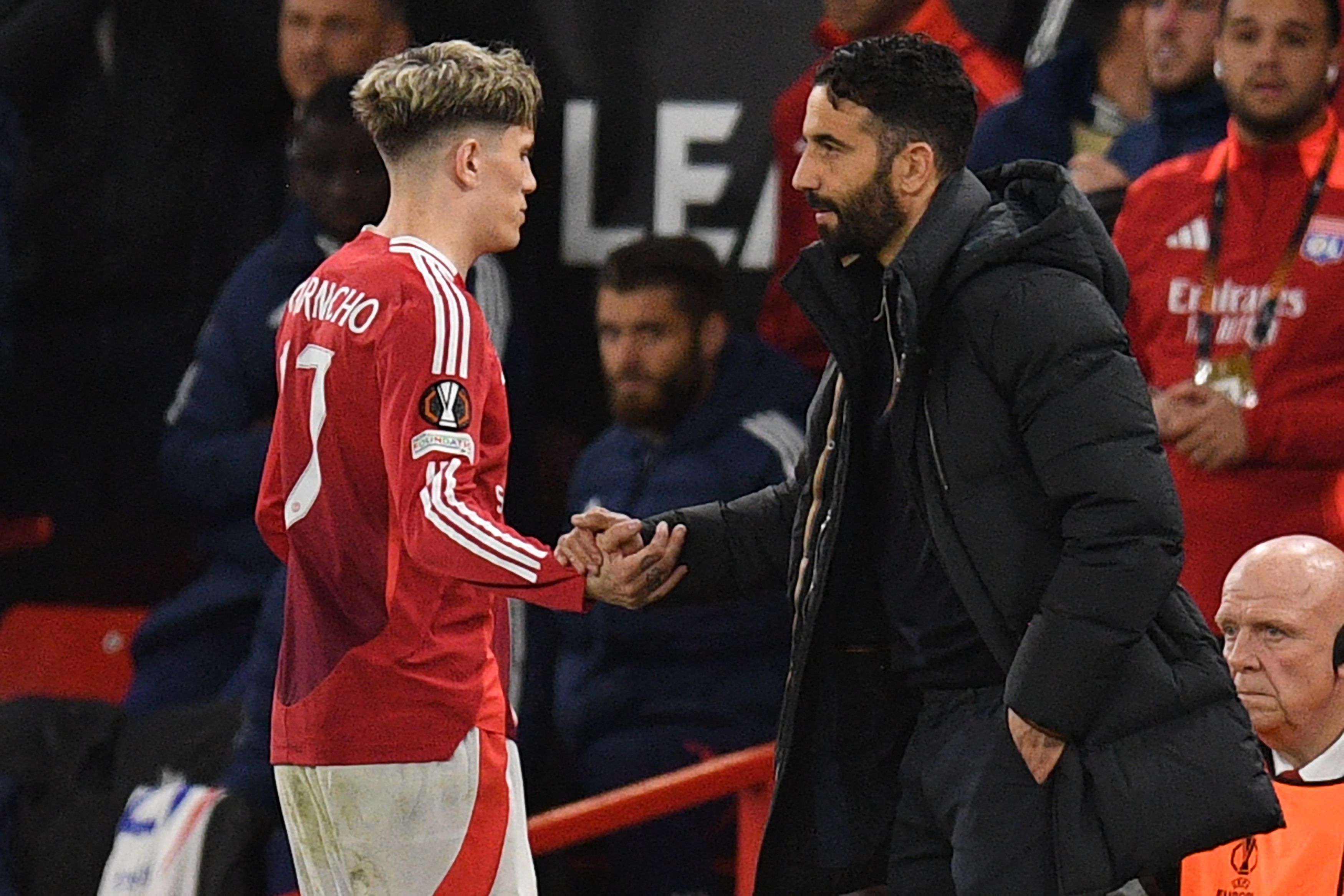 Manchester United's Portuguese head coach Ruben Amorim (R) shakes hands with Manchester United's Argentinian midfielder #17 Alejandro Garnacho (L) as he leaves the game, substituted during the UEFA Europa league quarter-final final, second leg football match between Manchester United and Lyon at Old Trafford stadium in Manchester, north west England, on April 17, 2025. (Photo by Oli SCARFF / AFP)