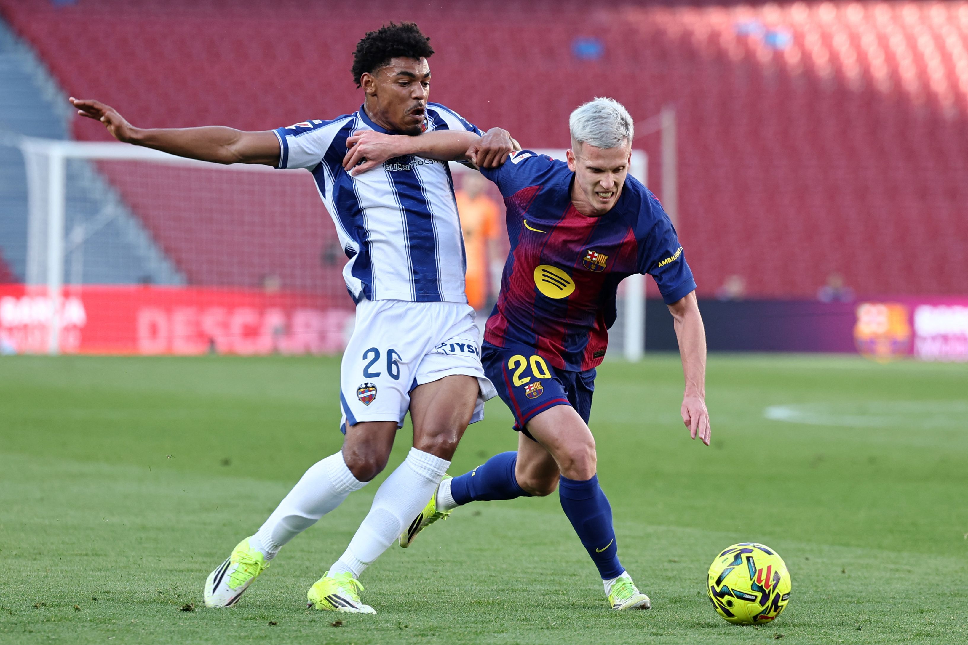 Levante's Spanish forward #26 Kareem Tunde and Barcelona's Spanish midfielder #20 Daniel Olmo fight for the ball during the Spanish league football match between FC Barcelona and Levante UD at Camp Nou Stadium in Barcelona on February 22, 2026. (Photo by Josep LAGO / AFP)