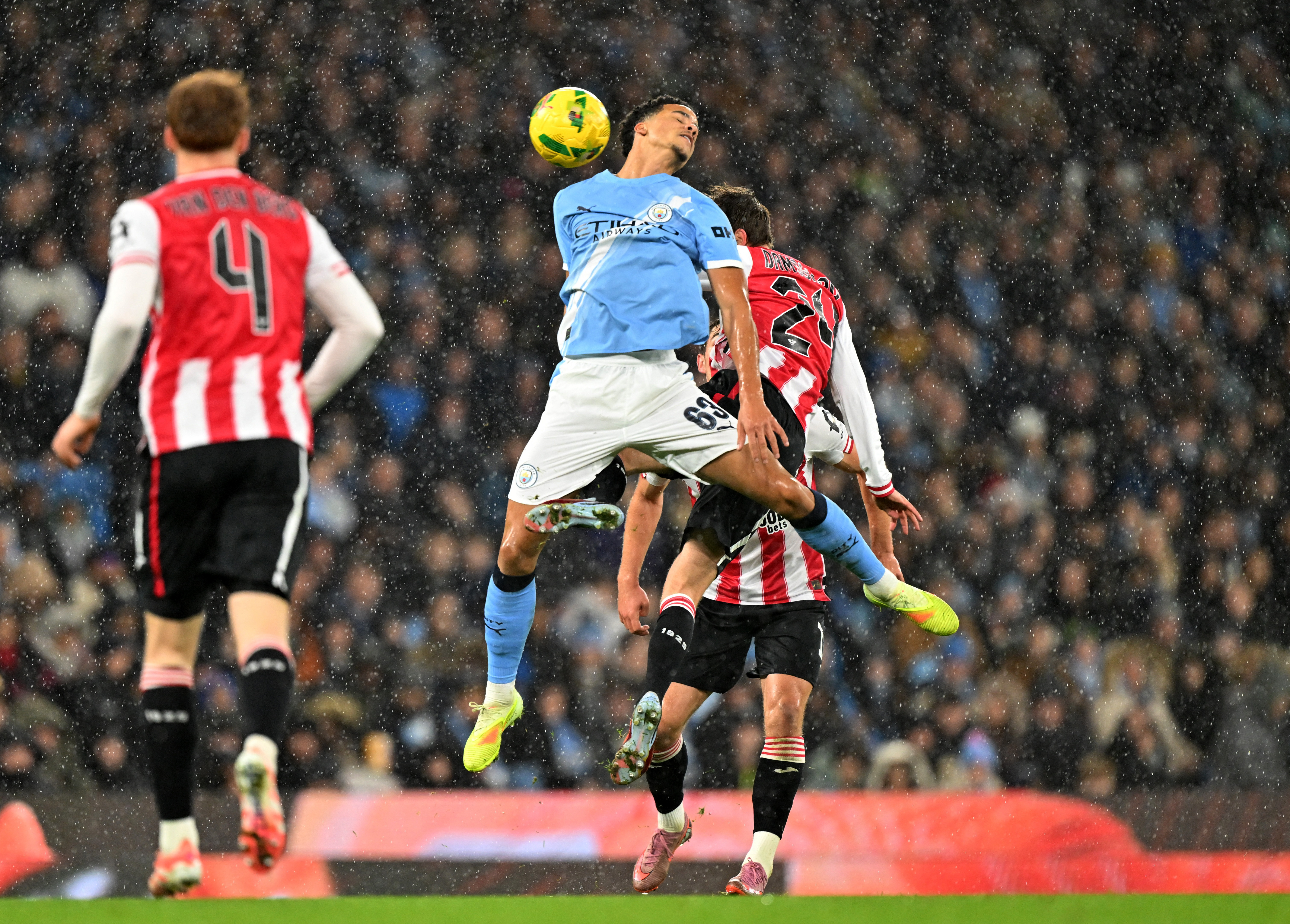 Soccer Football - Carabao Cup - Quarter Final - Manchester City v Brentford - Etihad Stadium, Manchester, Britain - December 17, 2025  Manchester City's Divine Mukasa in action with Brentford's Mikkel Damsgaard REUTERS/Peter Powell EDITORIAL USE ONLY. NO USE WITH UNAUTHORIZED AUDIO, VIDEO, DATA, FIXTURE LISTS, CLUB/LEAGUE LOGOS OR 'LIVE' SERVICES. ONLINE IN-MATCH USE LIMITED TO 120 IMAGES, NO VIDEO EMULATION. NO USE IN BETTING, GAMES OR SINGLE CLUB/LEAGUE/PLAYER PUBLICATIONS. PLEASE CONTACT YOUR ACCOUNT REPRESENTATIVE FOR FURTHER DETAILS..