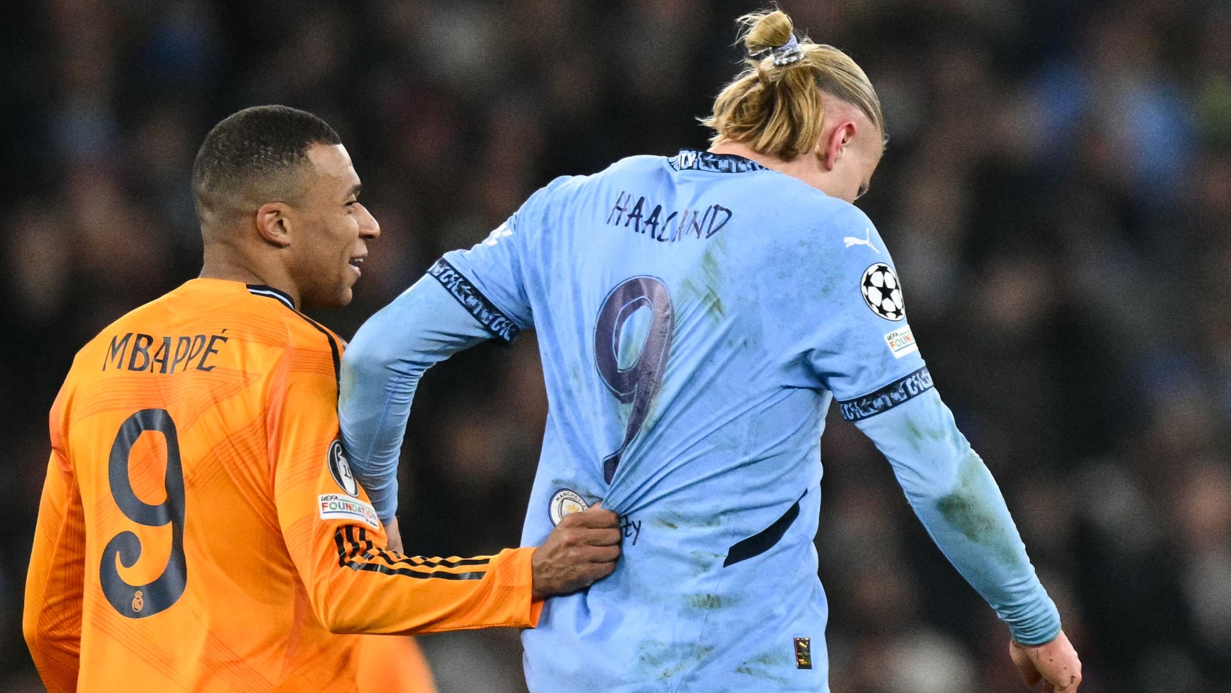 Real Madrid's French forward #09 Kylian Mbappe (L) pull sthe jersey of Manchester City's Norwegian striker #09 Erling Haaland during the UEFA Champions League football match between Manchester City and Real Madrid at the Etihad Stadium in Manchester, north west England, on February 11, 2025. (Photo by Oli SCARFF / AFP)