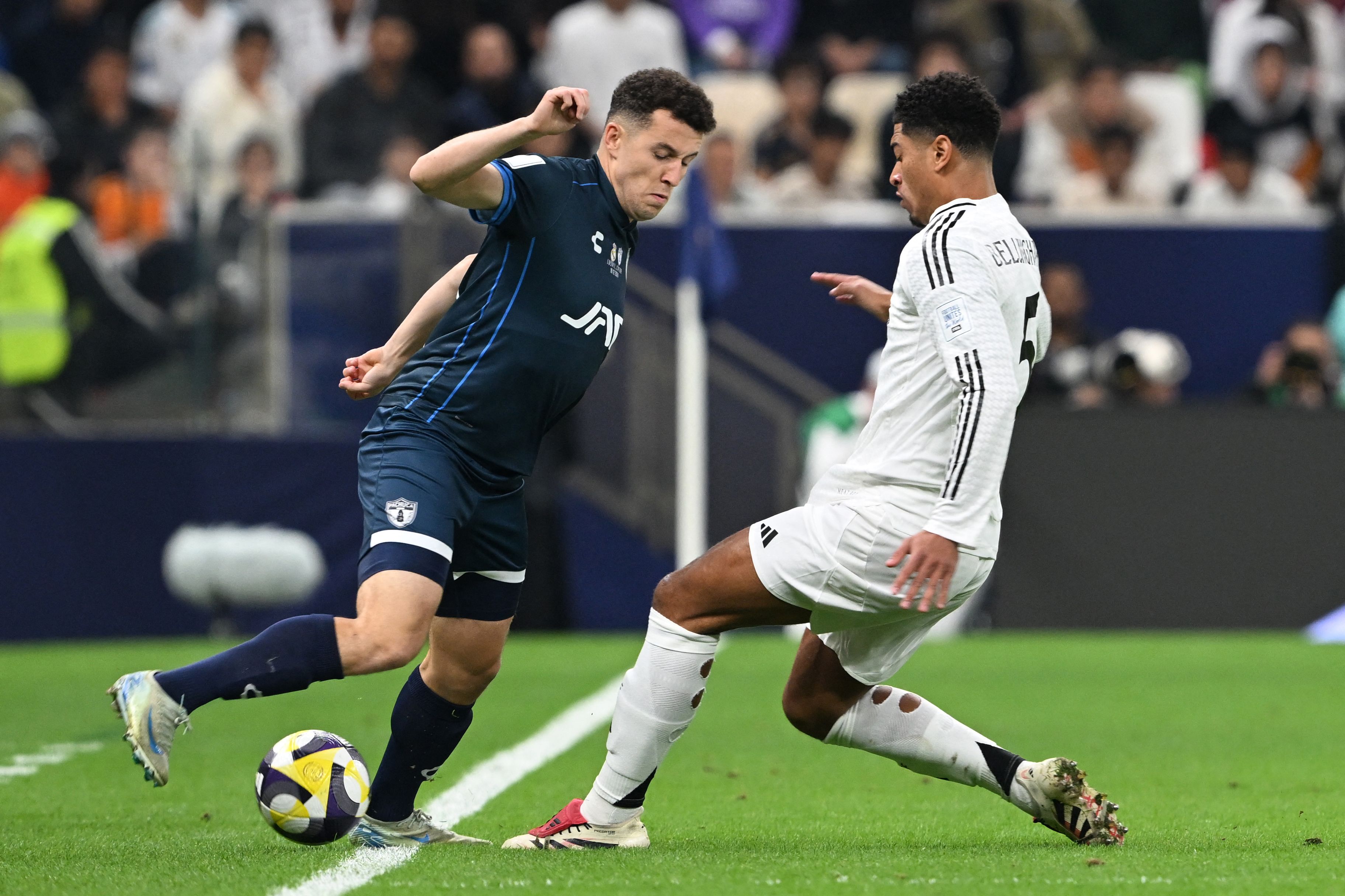 Real Madrid's English midfielder #5 Jude Bellingham vies for the ball against Pachuca's Moroccan midfielder #11 Oussama Idrissi during the 2024 FIFA Intercontinental Cup final football match between Spain's Real Madrid and Mexico's Pachuca at the Lusail Stadium in Doha on December 18, 2024. (Photo by Mahmud HAMS / AFP)