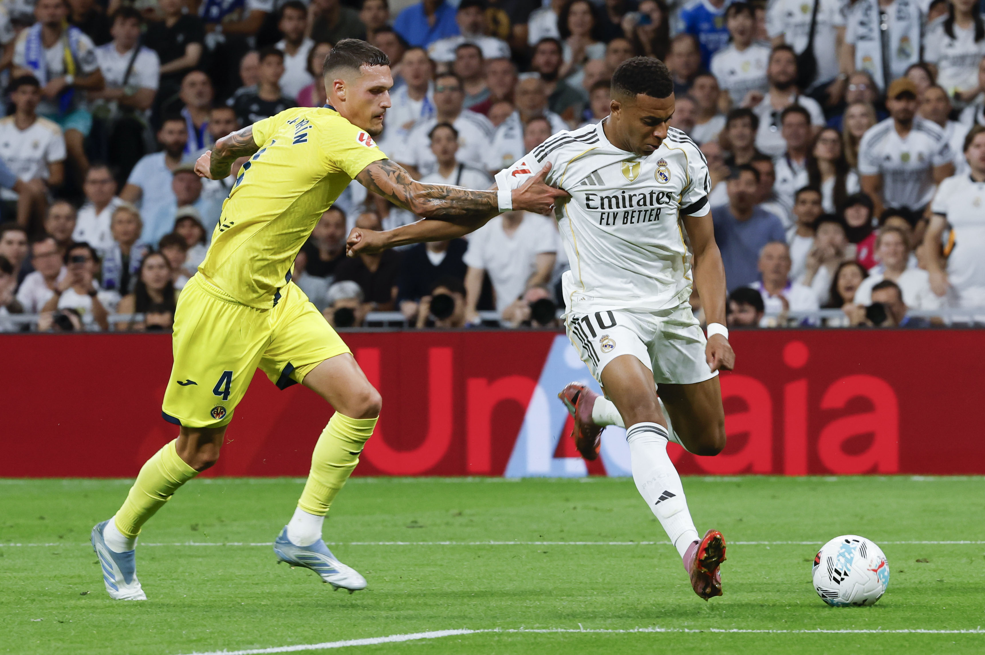 MADRID, 04/10/2025.- El delantero del Real Madrid Kylian Mbappé (d) juega un balón ante Rafa Marín, del Villarreal, durante el partido de LaLiga de fútbol que Real Madrid y Villarreal disputan este sábado en el estadio Santiago Bernabéu. EFE/Guillén