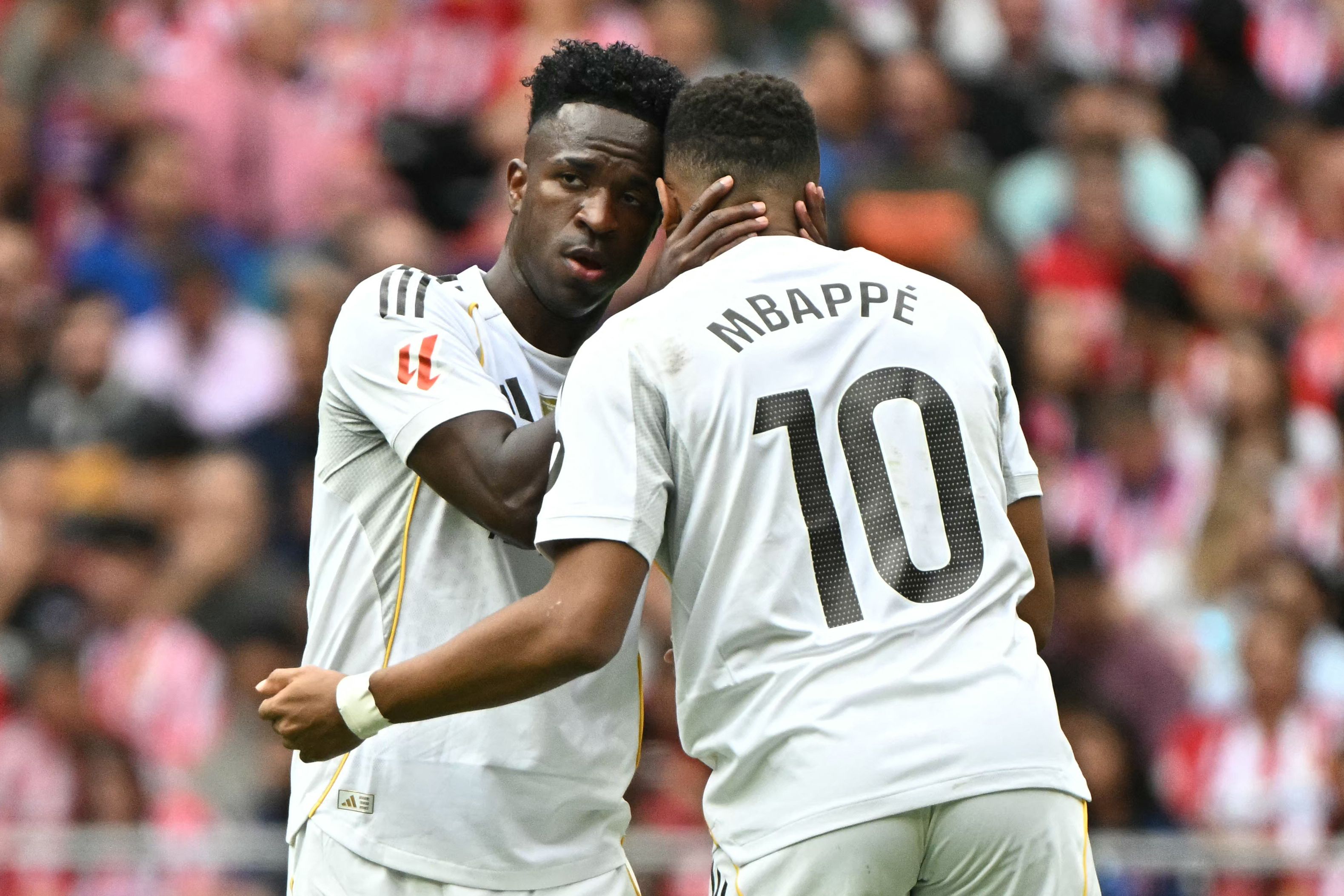 Real Madrid's French forward #10 Kylian Mbappe celebrates with Real Madrid's Brazilian forward #07 Vinicius Junior scoring his team's first goal during the Spanish league football match between Club Atletico de Madrid and Real Madrid CF at the Metropolitano stadium in Madrid on September 27, 2025. (Photo by Javier SORIANO / AFP)