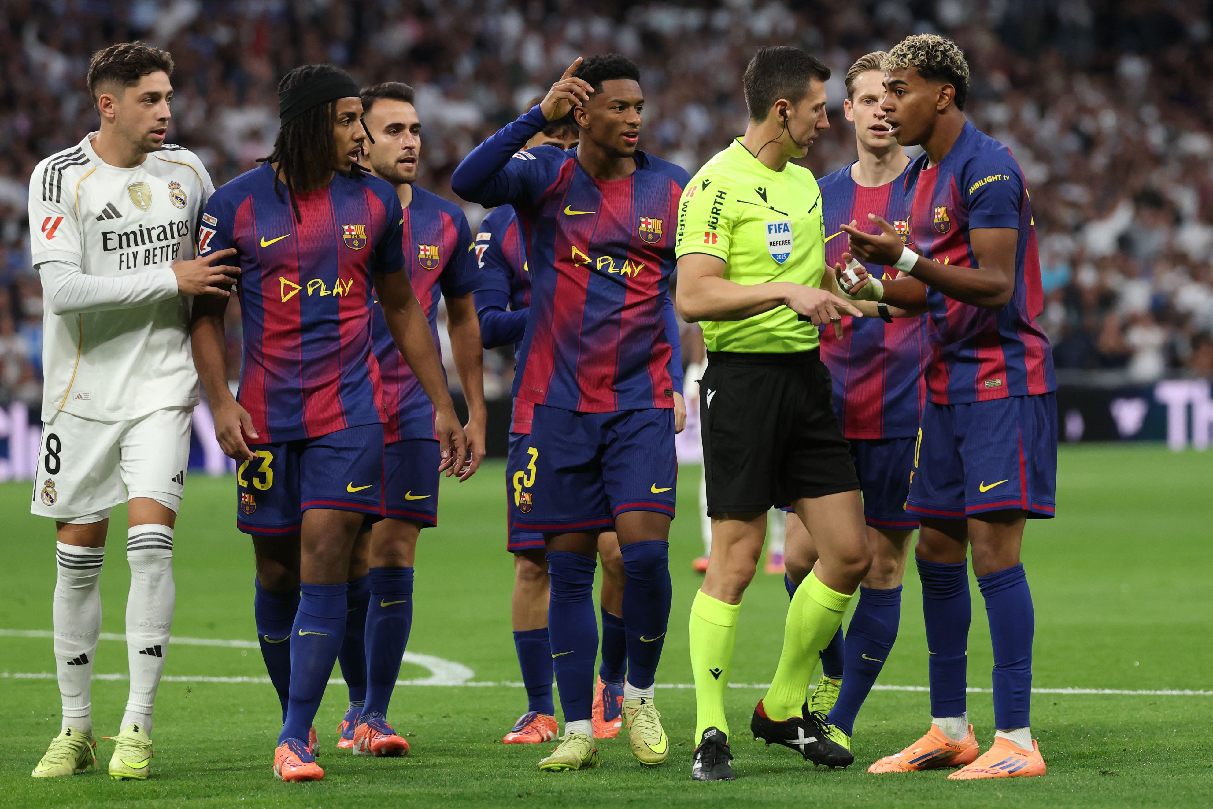 Barcelona's Spanish forward #10 Lamine Yamal (R) speaks with Spanish referee Soto Grado during the Spanish league football match between Real Madrid CF and FC Barcelona at Santiago Bernabeu Stadium in Madrid on October 26 , 2025. (Photo by Oscar DEL POZO / AFP)