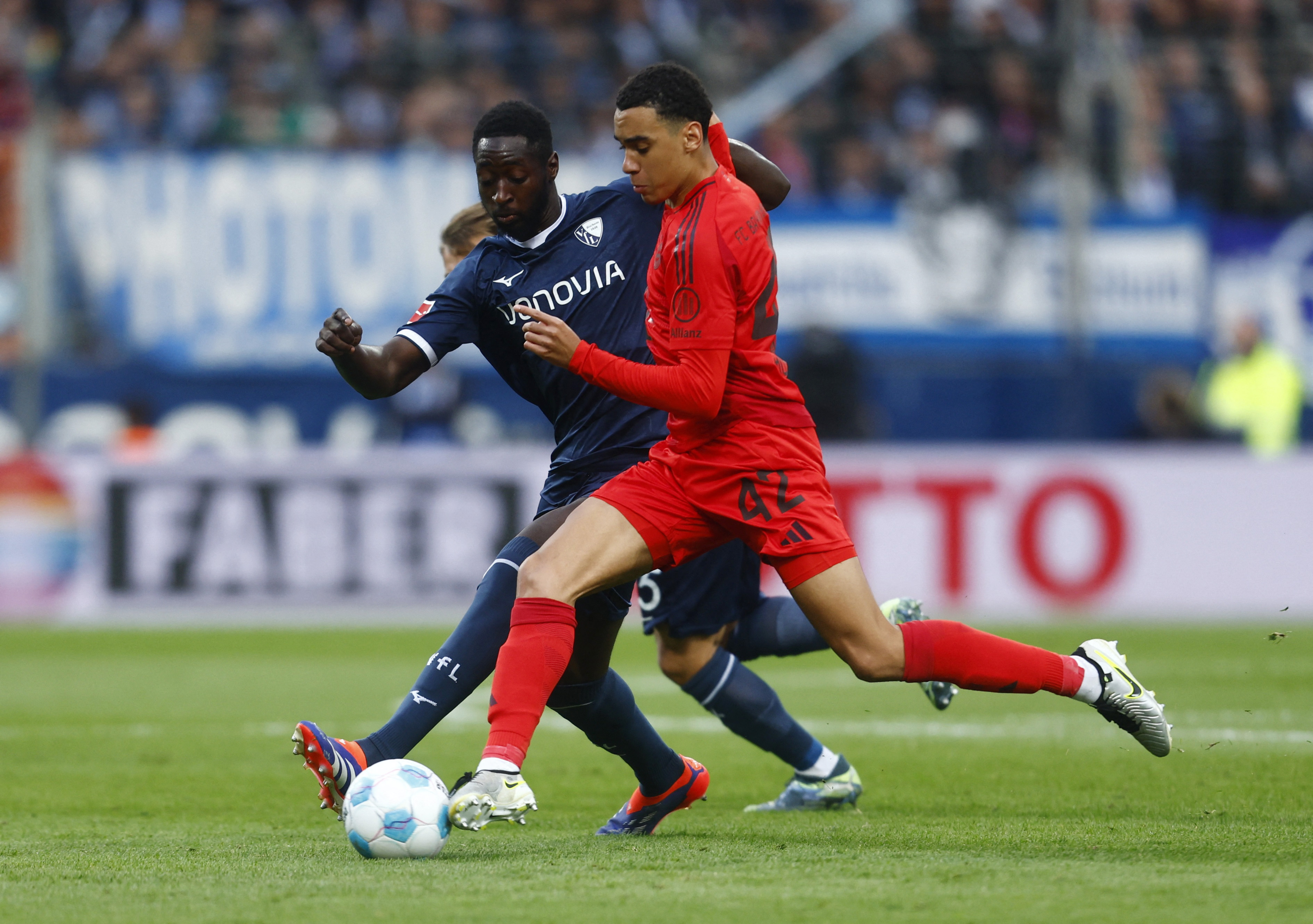 Soccer Football - Bundesliga - VfL Bochum v Bayern Munich - Vonovia Ruhrstadion, Bochum, Germany - October 27, 2024 Bayern Munich's Jamal Musiala in action with VfL Bochum's Ibrahima Sissoko REUTERS/Leon Kuegeler DFL REGULATIONS PROHIBIT ANY USE OF PHOTOGRAPHS AS IMAGE SEQUENCES AND/OR QUASI-VIDEO.