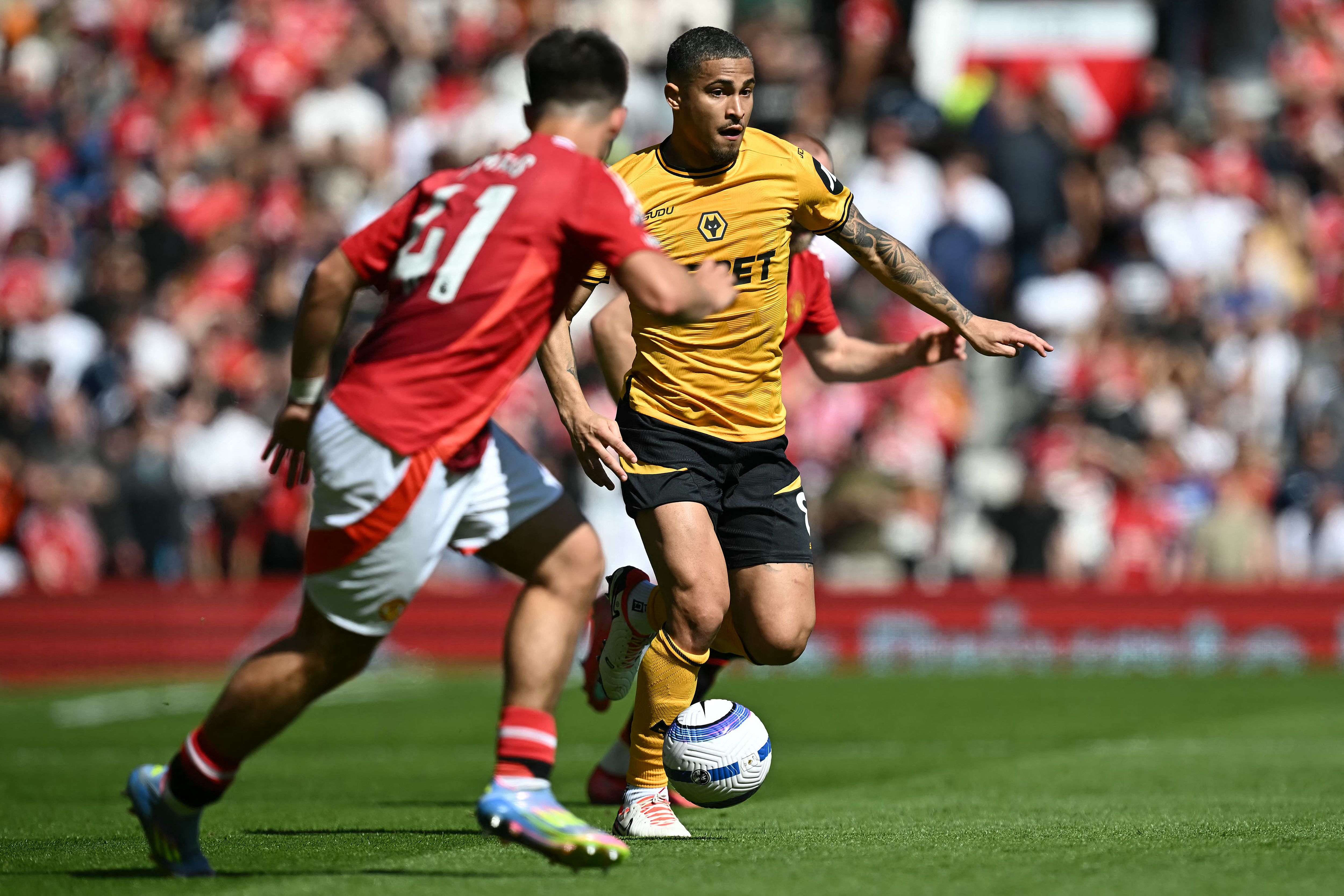 Manchester United's English defender #41 Harry Amass (L) vies with Wolverhampton Wanderers' Brazilian midfielder #08 Joao Gomes during the English Premier League football match between Manchester United and Wolverhampton Wanderers at Old Trafford in Manchester, north west England, on April 20, 2025. (Photo by Paul ELLIS / AFP) / RESTRICTED TO EDITORIAL USE. No use with unauthorized audio, video, data, fixture lists, club/league logos or 'live' services. Online in-match use limited to 120 images. An additional 40 images may be used in extra time. No video emulation. Social media in-match use limited to 120 images. An additional 40 images may be used in extra time. No use in betting publications, games or single club/league/player publications. / 