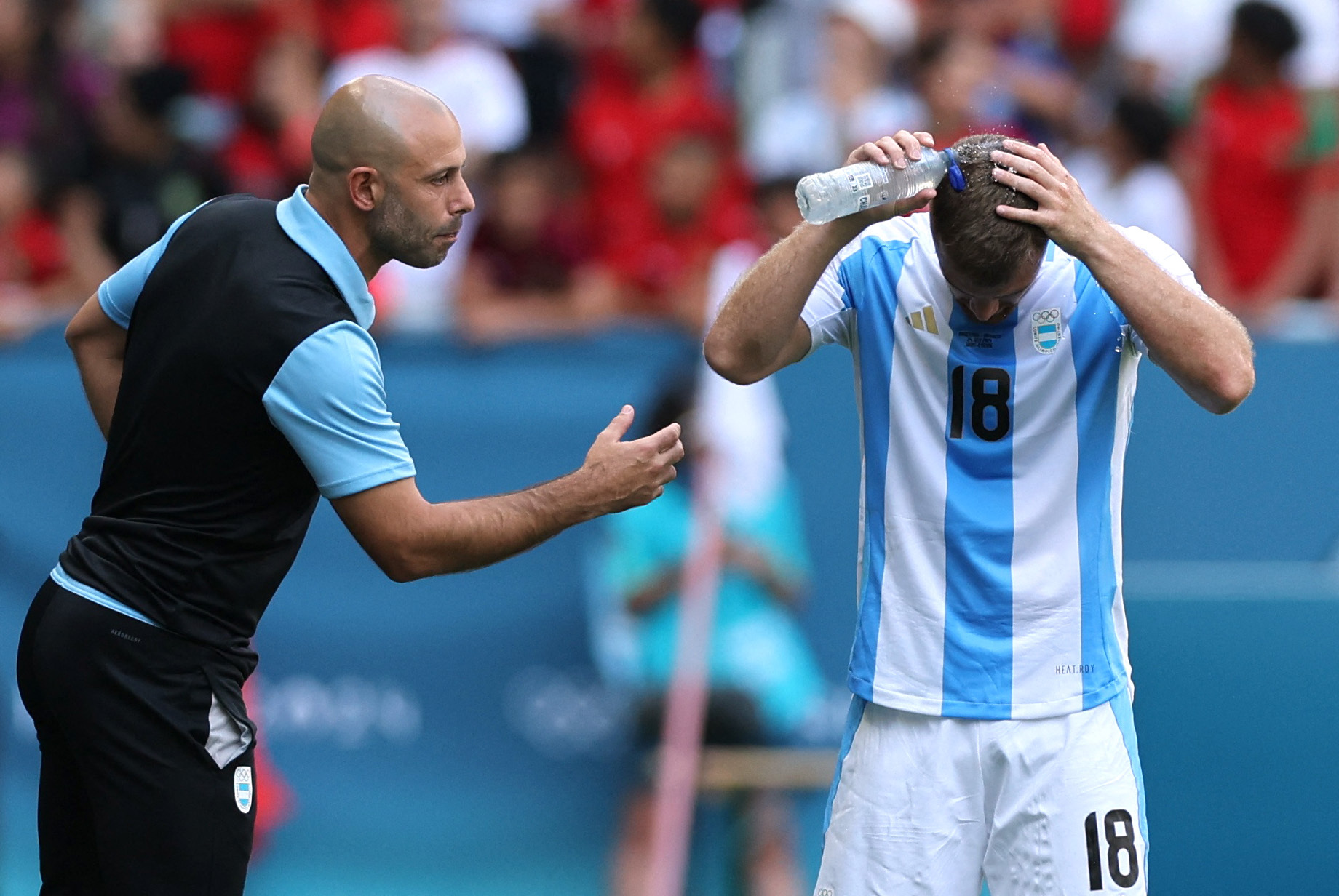 Paris 2024 Olympics - Football - Men's Group B - Argentina vs Morocco - Geoffroy-Guichard Stadium, Saint-Etienne, France - July 24, 2024. Argentina coach Javier Mascherano talks to Lucas Beltran of Argentina during a break in play REUTERS/Thaier Al-Sudani