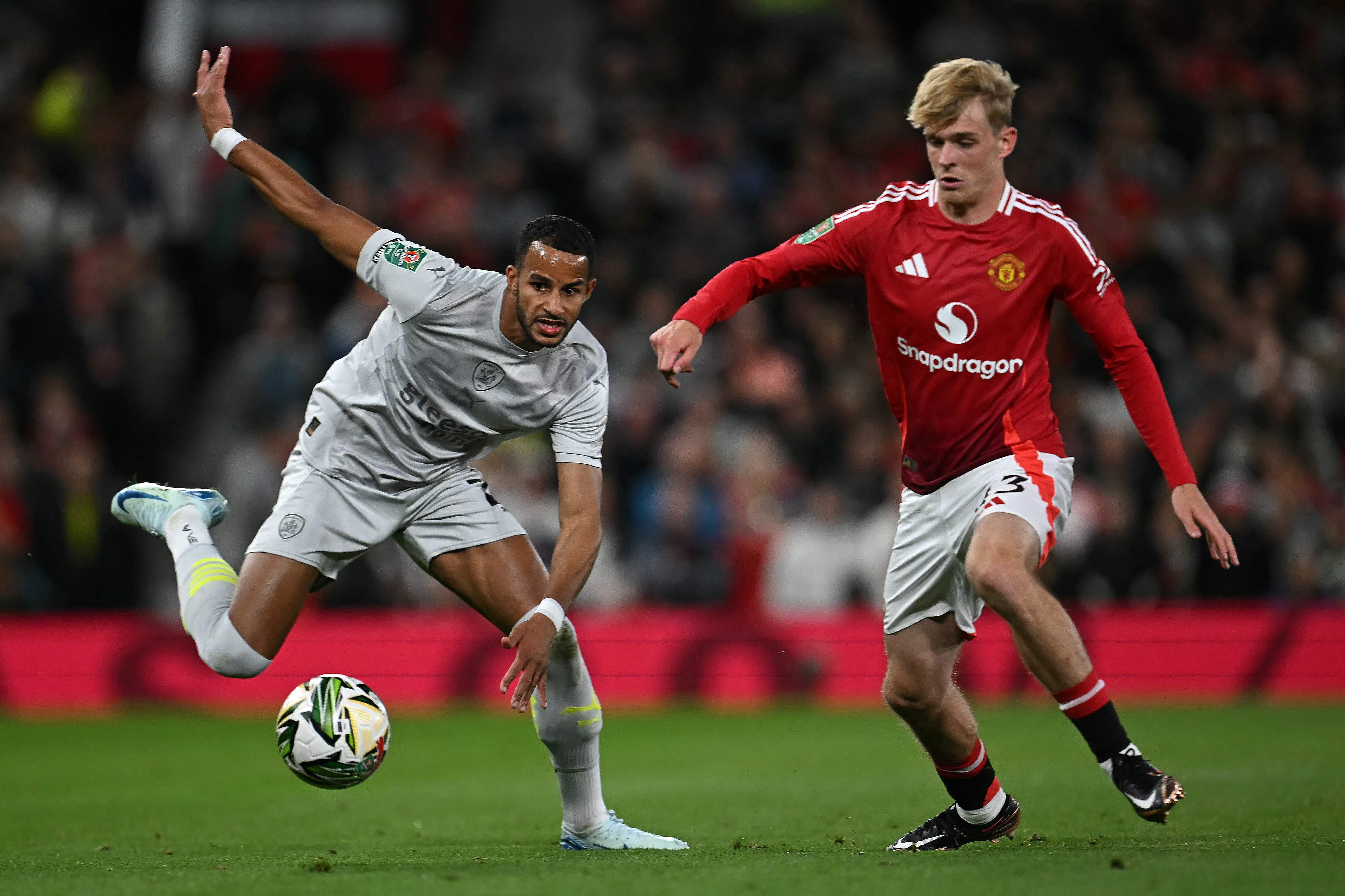 Barnsley's Irish defender #07 Corey O'Keeffe (L) vies with Manchester United's English midfielder #43 Toby Collyer during the English League Cup third round football match between Manchester United and Barnsley at Old Trafford in Manchester, north west England, on September 17, 2024. (Photo by Paul ELLIS / AFP) / RESTRICTED TO EDITORIAL USE. No use with unauthorized audio, video, data, fixture lists, club/league logos or 'live' services. Online in-match use limited to 120 images. An additional 40 images may be used in extra time. No video emulation. Social media in-match use limited to 120 images. An additional 40 images may be used in extra time. No use in betting publications, games or single club/league/player publications. / 