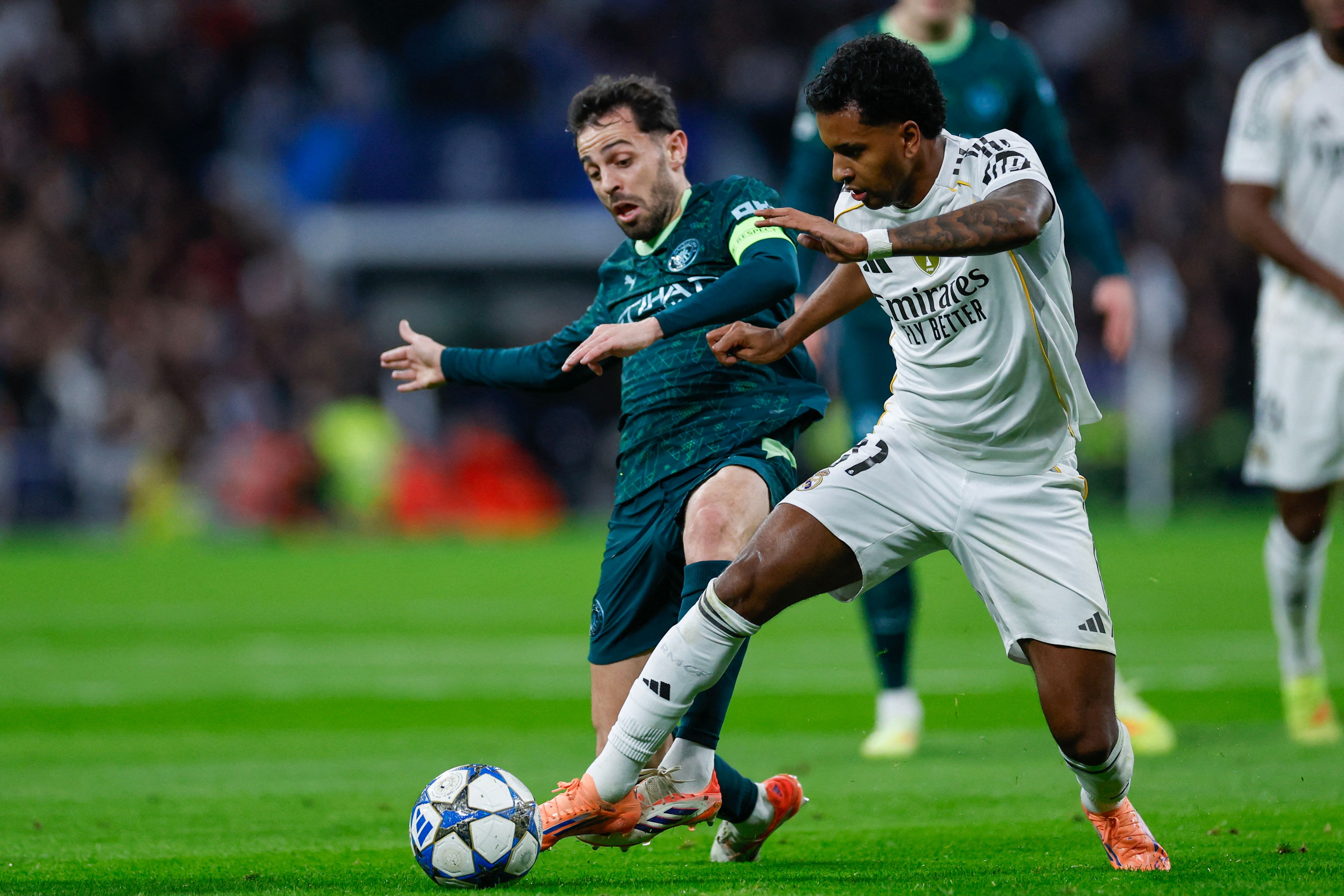 Manchester City's Portuguese midfielder #20 Bernardo Silva (L) and Real Madrid's Brazilian forward #11 Rodrygo vie for the ball during the UEFA Champions League league phase day 6 football match between Real Madrid CF and Manchester City at Santiago Bernabeu Stadium in Madrid on December 10, 2025. (Photo by Oscar DEL POZO / AFP)