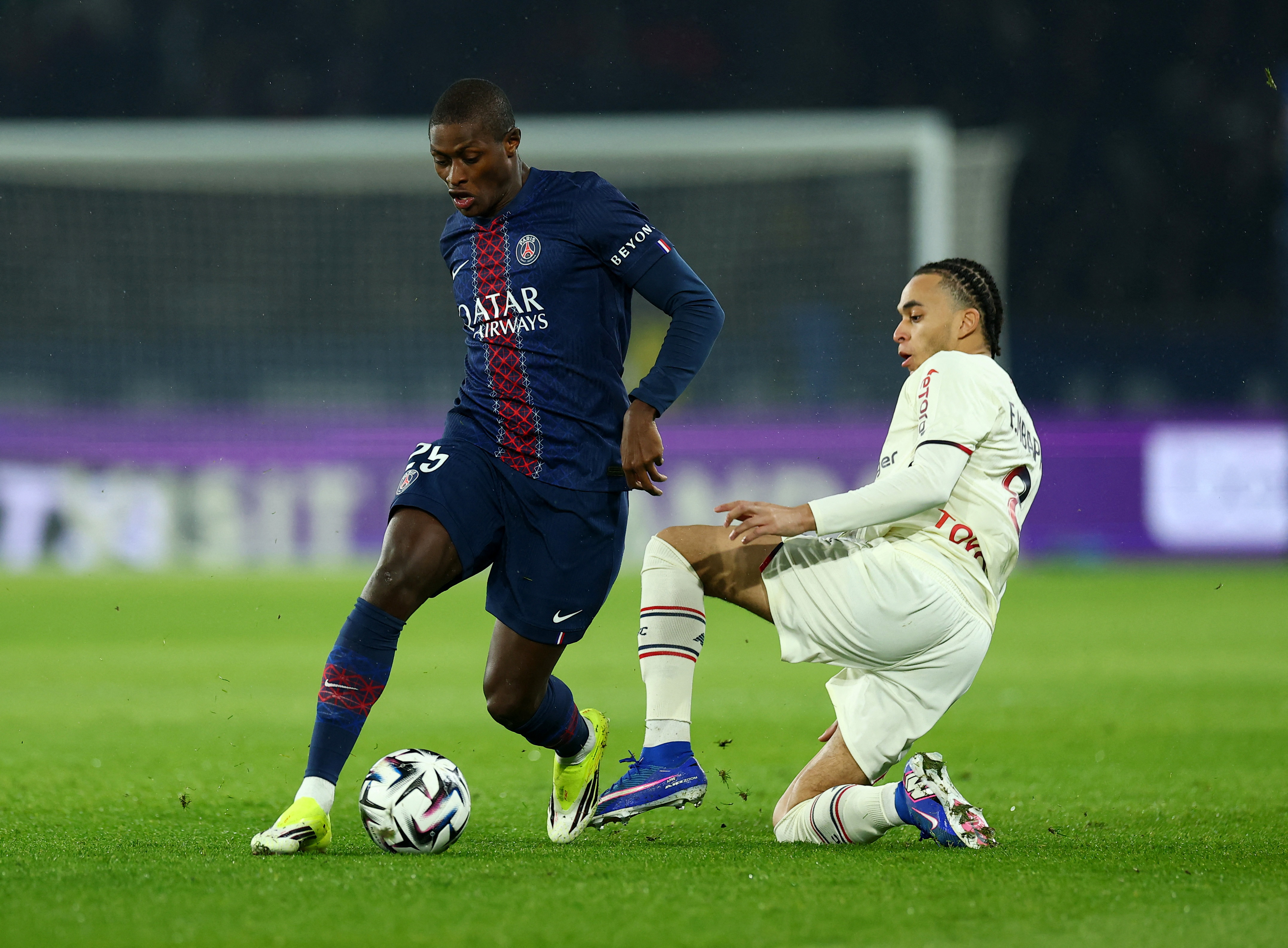 Soccer Football - Ligue 1 - Paris St Germain v Lille - Parc des Princes, Paris, France - January 16, 2026 Paris St Germain's Nuno Mendes in action with Lille's Ethan Mbappe REUTERS/Gonzalo Fuentes