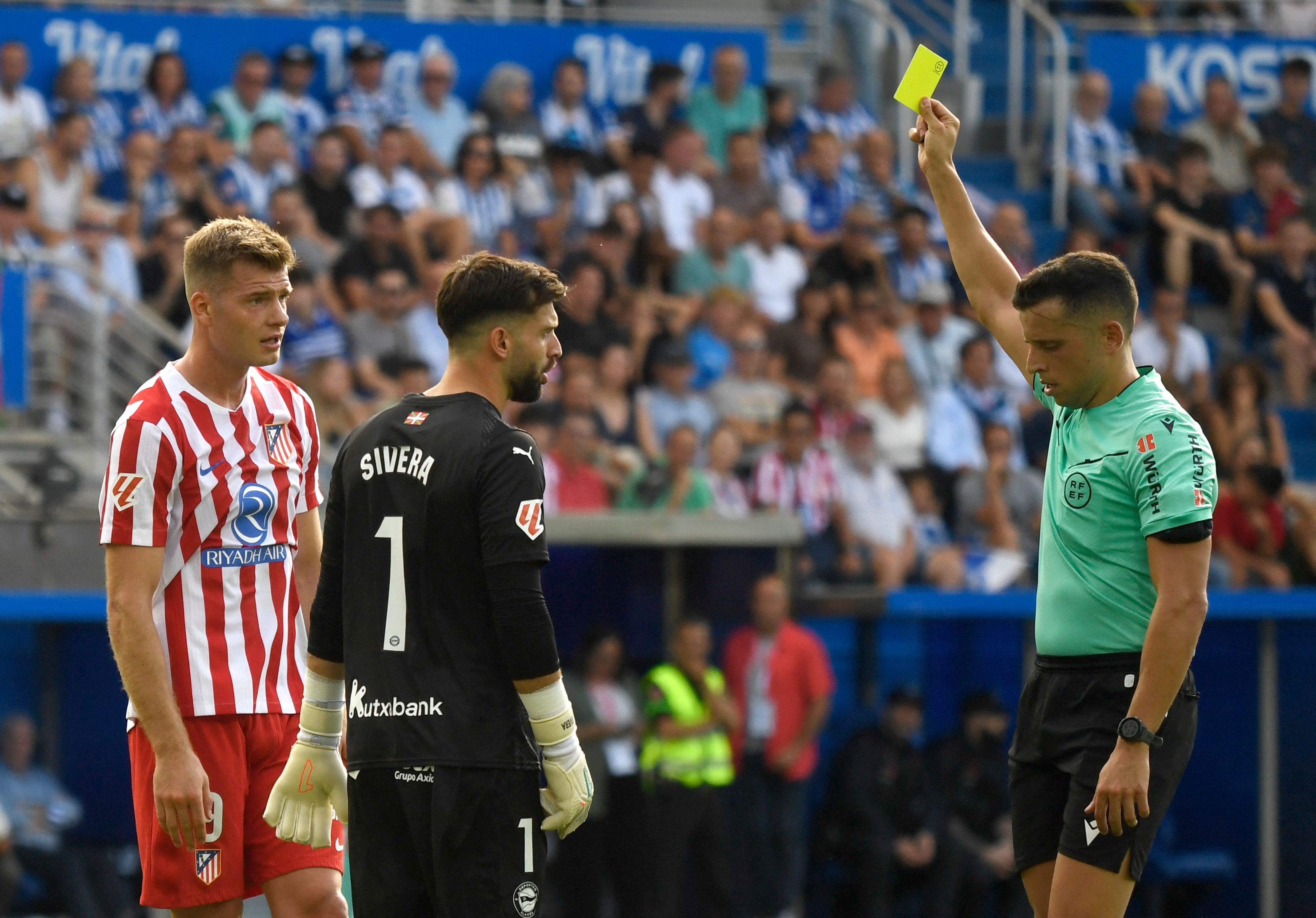 Spanish referee Victor Garcia Verdura shows a yellow card to Atletico Madrid's Norwegian forward #09 Alexander Sorloth during the Spanish league football match between Deportivo Alaves and Club Atletico de Madrid at the Mendizorroza stadium in Vitoria on August 30, 2025. (Photo by ANDER GILLENEA / AFP)
