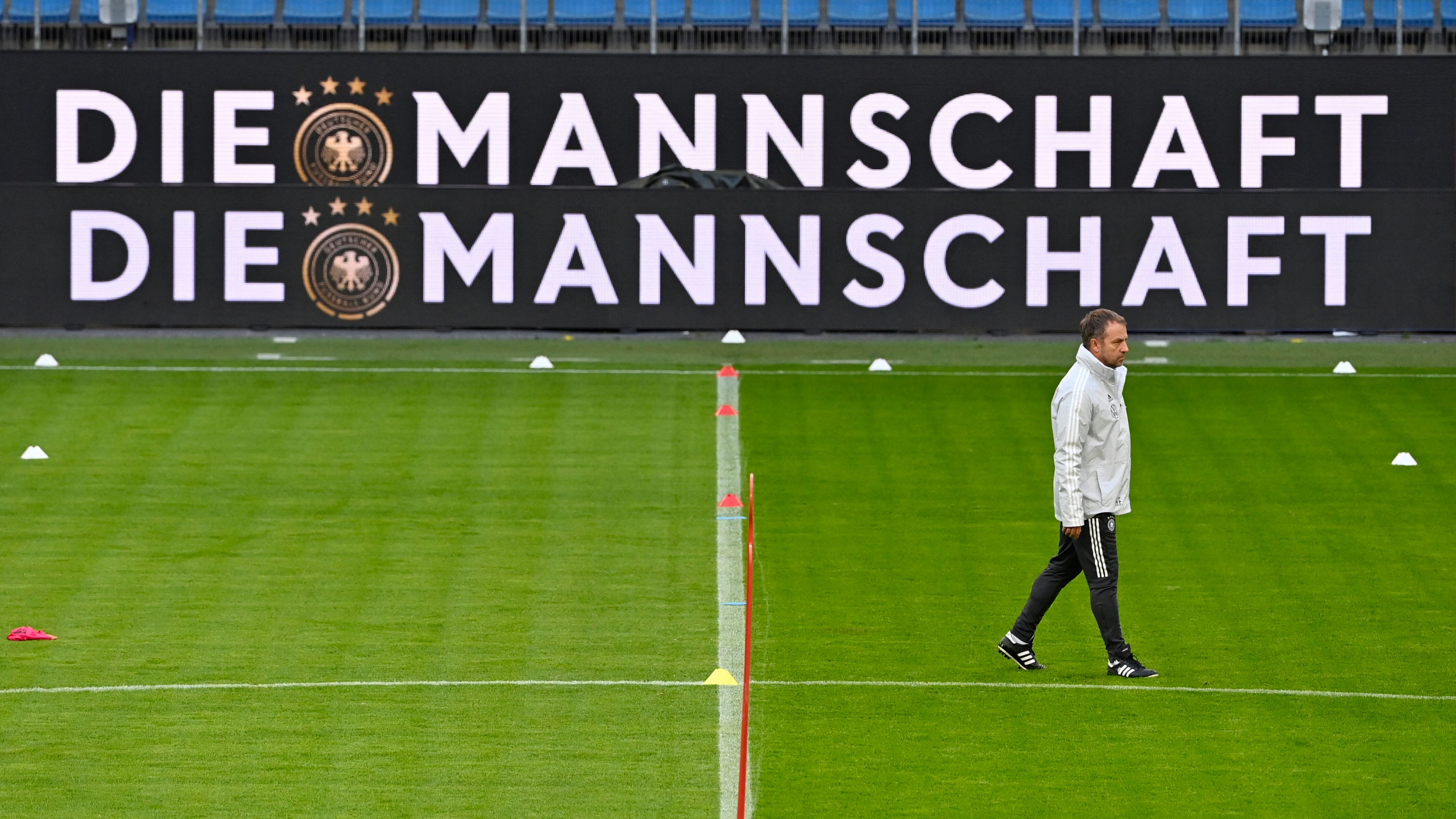 (FILES) Germany's head coach Hans-Dieter Flick walks across the pitch during a training session on October 7, 2021 in Hamburg, northern Germany, before the team's 2022 FIFA World Cup Group J qualification football match against Romania on October 8. Germany's coach Hansi Flick was fired just nine months from hosting Euro 2024 after Saturday's 4-1 thumping by Japan in Wolfsburg, the German FA (DFB) announced on September 10, 2023. The Germans were thoroughly outclassed by the Samurai Blue on home soil in the friendly, with only some acrobatic 'keeping from Marc-Andre ter Stegen preventing the score from eclipsing 2001's 5-1 loss to England in Munich. (Photo by John MACDOUGALL / AFP)