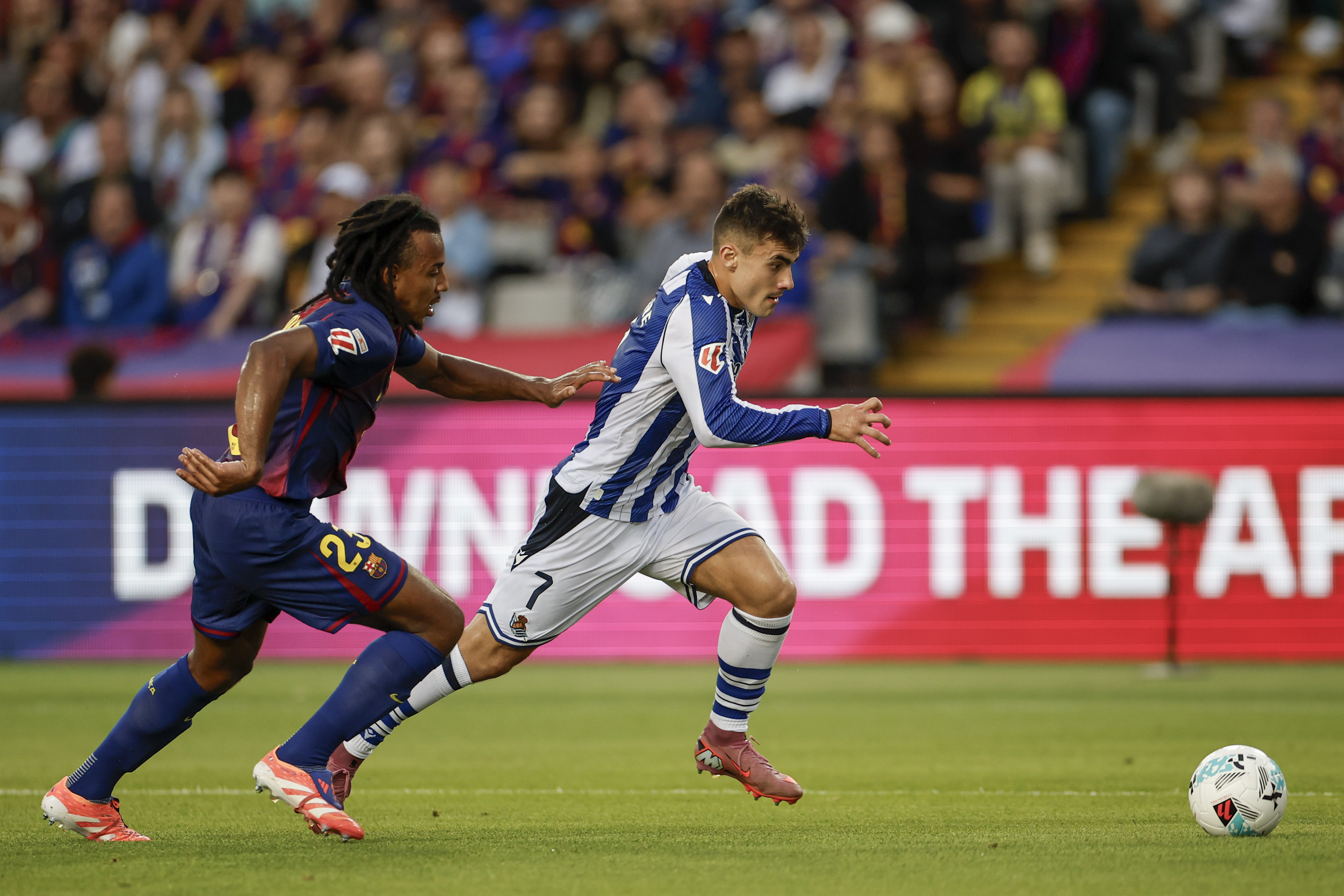 BARCELONA, 28/09/2025.- El delantero de la Real Sociedad, Ander Barrenetxea (d), se lleva el balón ante el defensa francés del FC Barcelona, Jules Koundé, durante el encuentro correspondiente a la séptima jornada de Liga EA Sports que FC Barcelona y Real Sociedad disputan este domingo. EFE/Alberto Estevez.