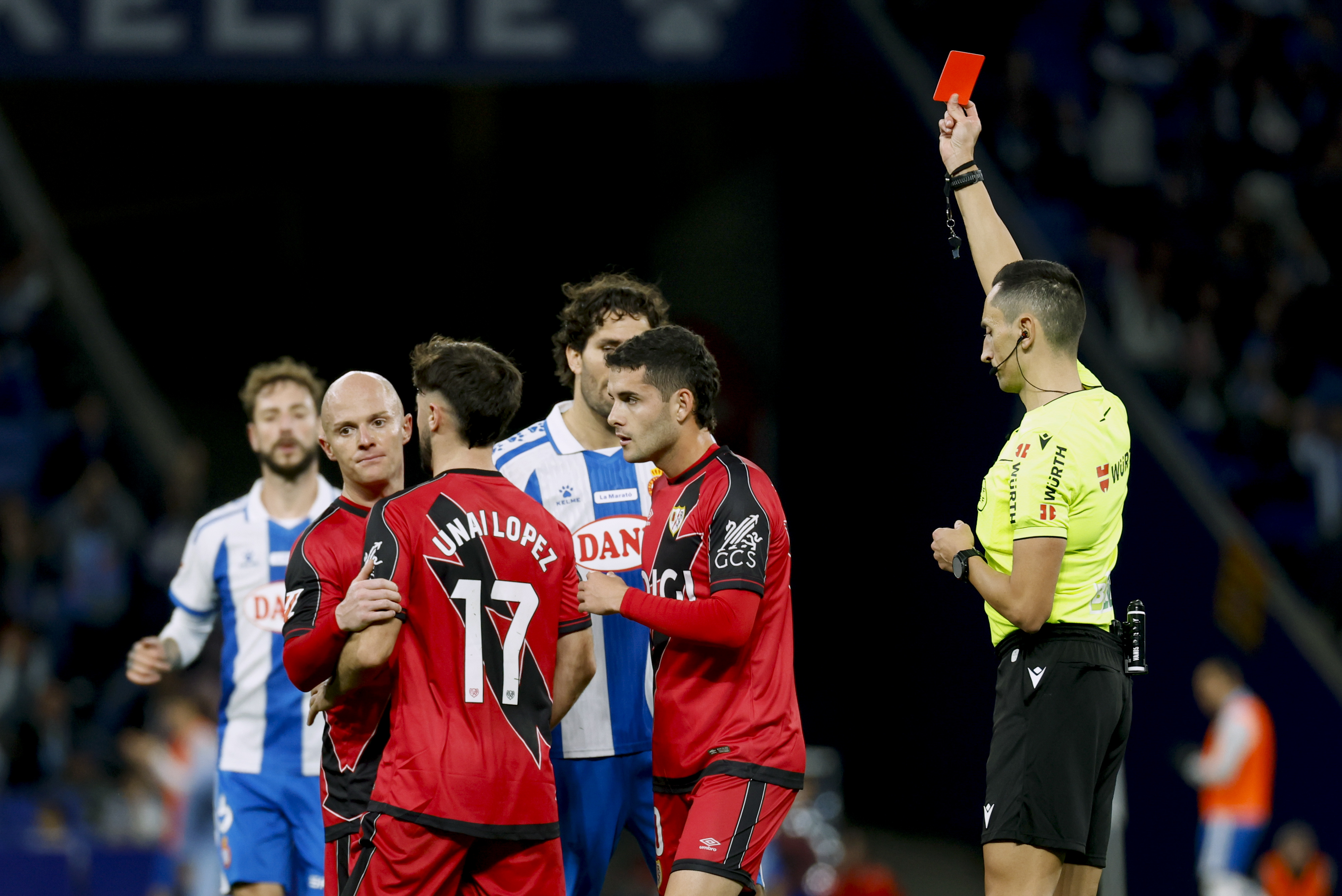 BARCELONA, 07/12/2025.- El árbitro Sánchez Martínez (d) muestra la tarjeta roja a Unai López (2-i), durante partido de LaLiga de fútbol que RCD Espayol y Rayo Vallecano disputan este domingo en el RCDE Stadium, en Barcelona. EFE/Toni Albir
