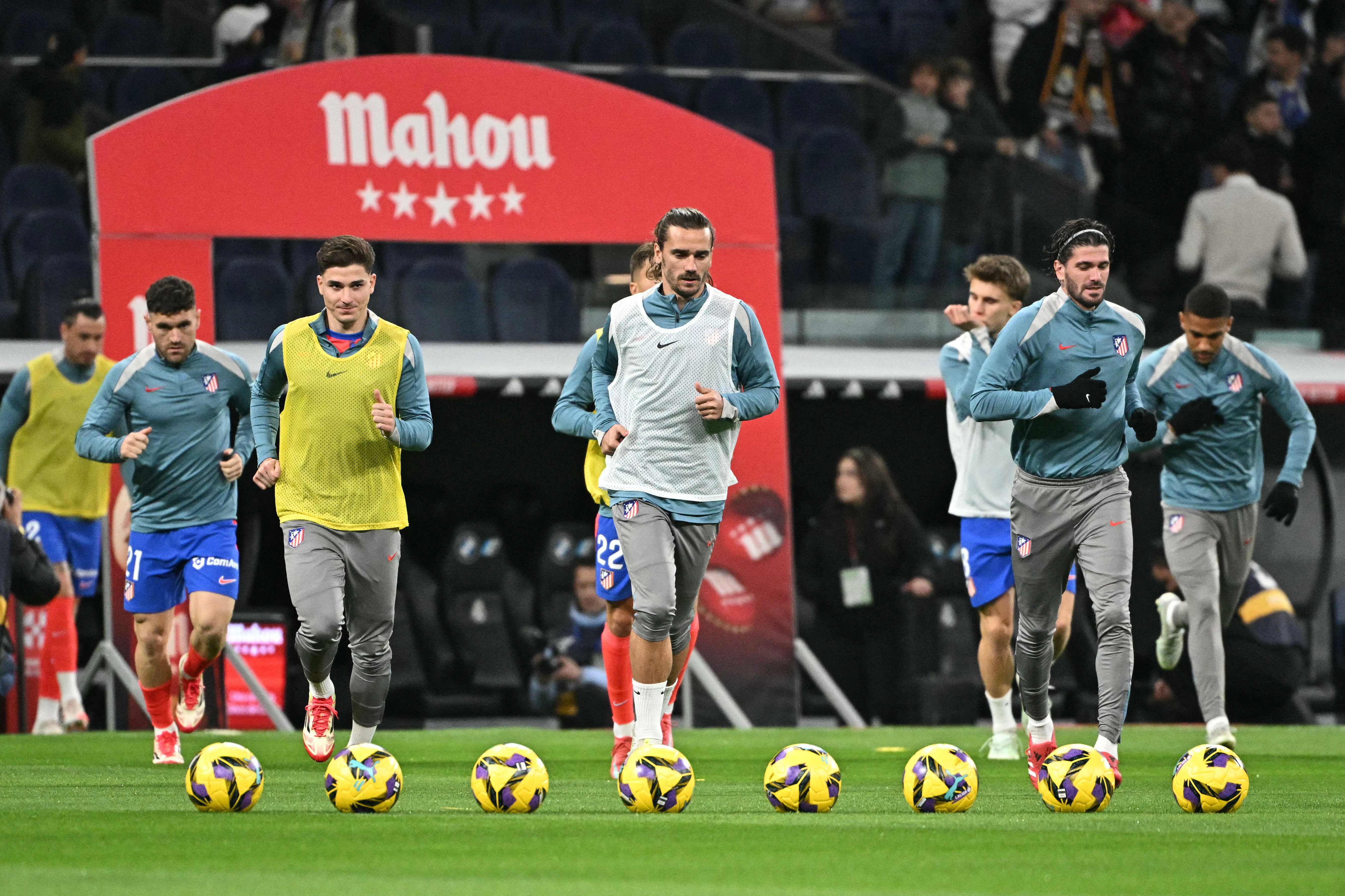 Atletico Madrid's French forward #07 Antoine Griezmann (C) and teammates warms up before the Spanish league football match between Real Madrid CF and Club Atletico de Madrid at Santiago Bernabeu Stadium in Madrid on February 8, 2025. (Photo by JAVIER SORIANO / AFP)