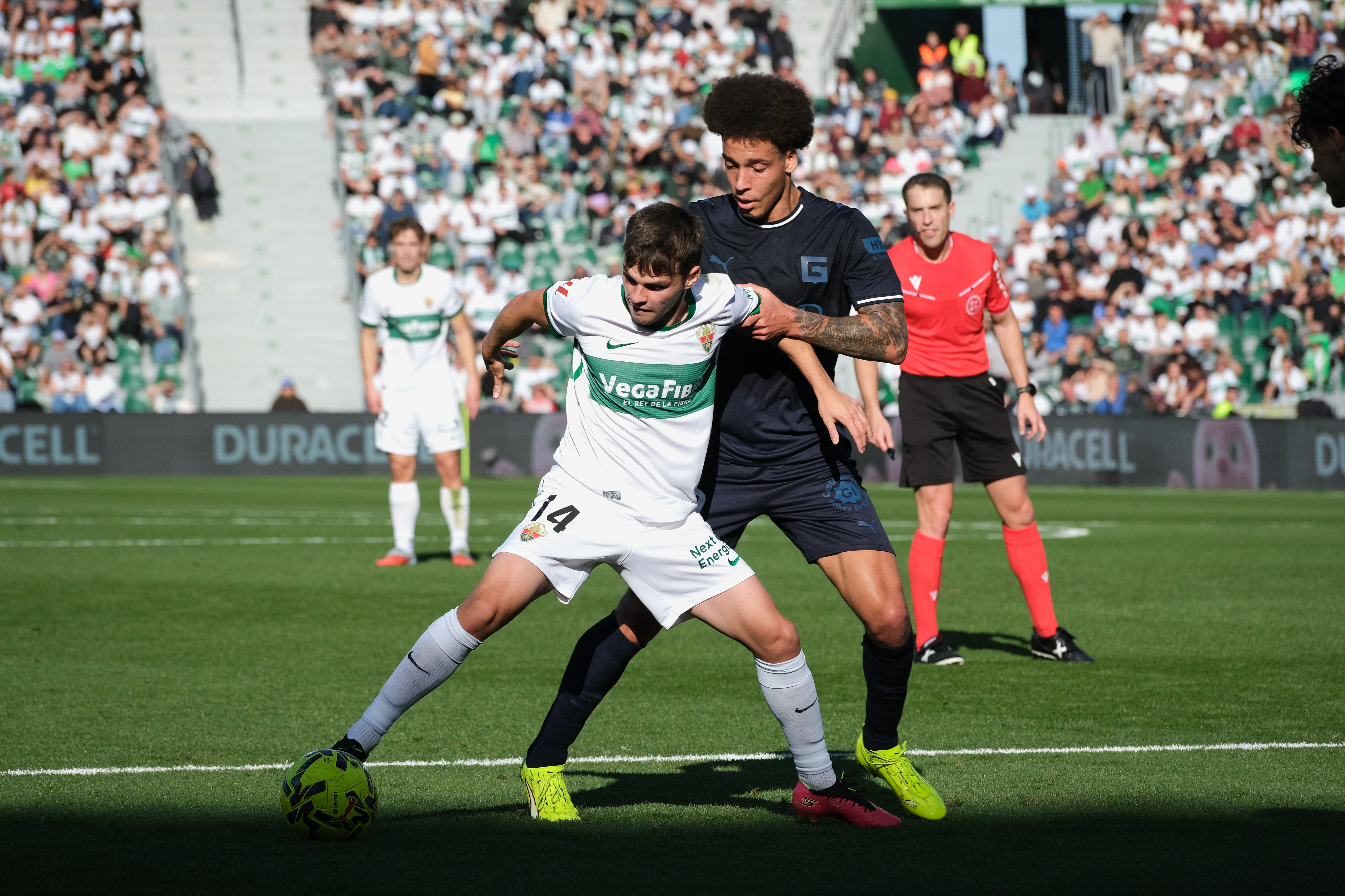 ELCHE (ALICANTE), 07/12/2025.- El centrocampista del Elche Aleix Febas (delante) se enfrenta a Axel Witsel, del Girona, durante el partido de la jornada 15 de LaLiga EA Sports disputado este domingo en el estadio Martínez Valero de Elche. EFE/Pablo Miranzo