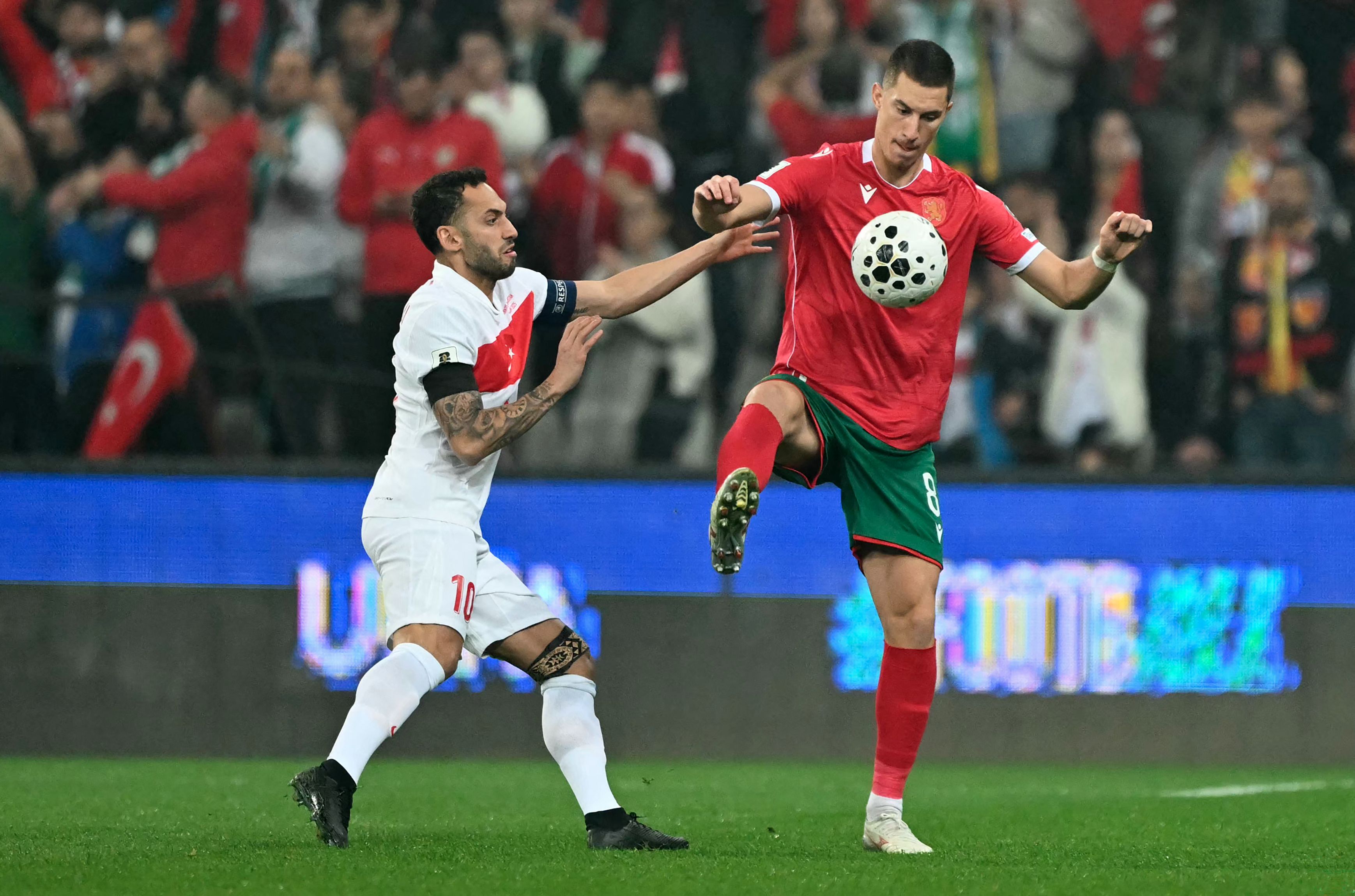 Turkey's midfielder #10 Hakan Calhanoglu (L) fights for the ball with Bulgaria's midfielder #08 Andrian Kraev during the FIFA World Cup 2026 European qualification football match between Turkey and Bulgaria at the Timsah Arena stadium, in Bursa, on November 15, 2025. (Photo by Ozan KOSE / AFP)