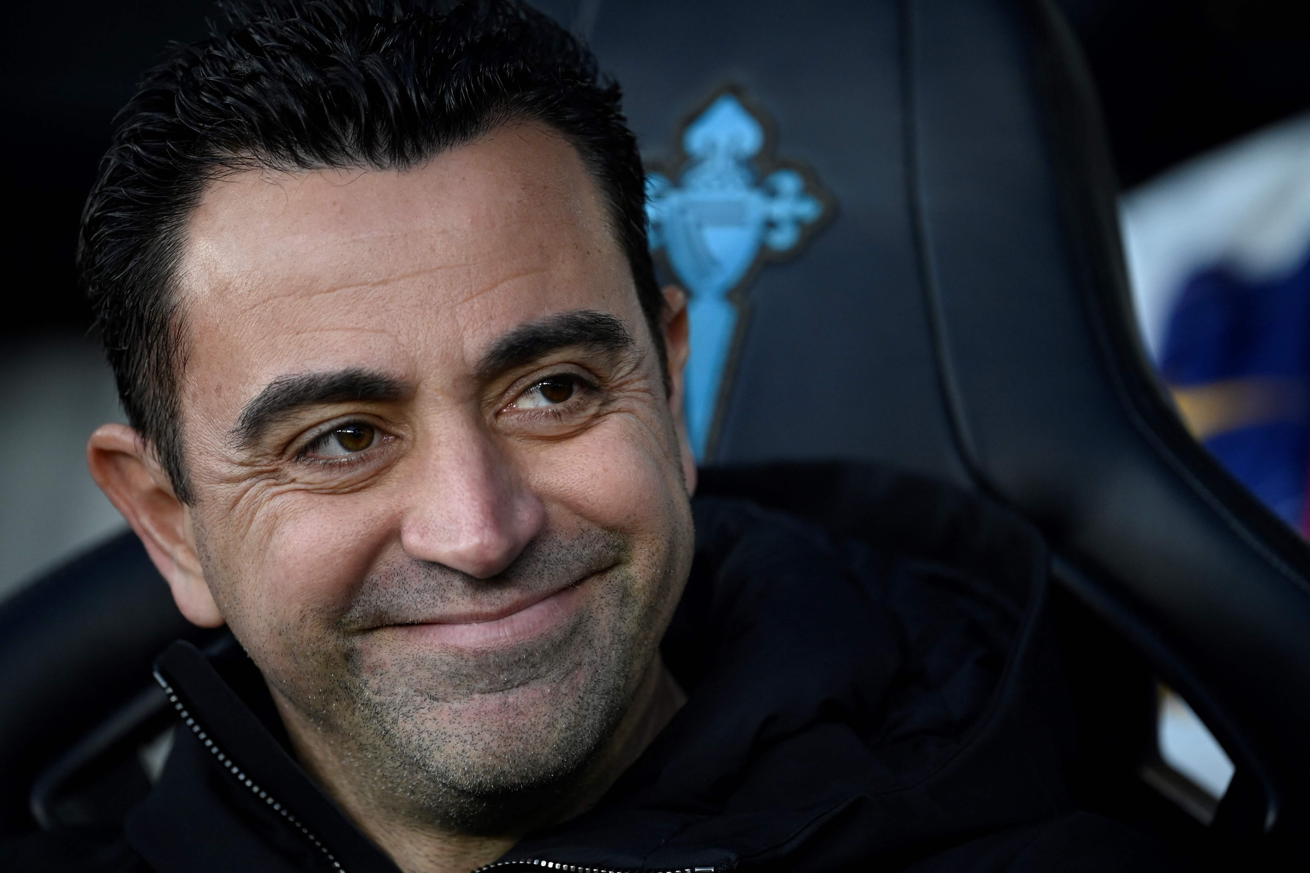 (FILES) Barcelona's Spanish coach Xavi smiles on the sidelines prior the Spanish league football match between RC Celta de Vigo and FC Barcelona at the Balaidos stadium in Vigo on February 17, 2024. Xavi is to remain Barcelona's coach according to the club, AFP reports on April 24, 2024. (Photo by MIGUEL RIOPA / AFP)