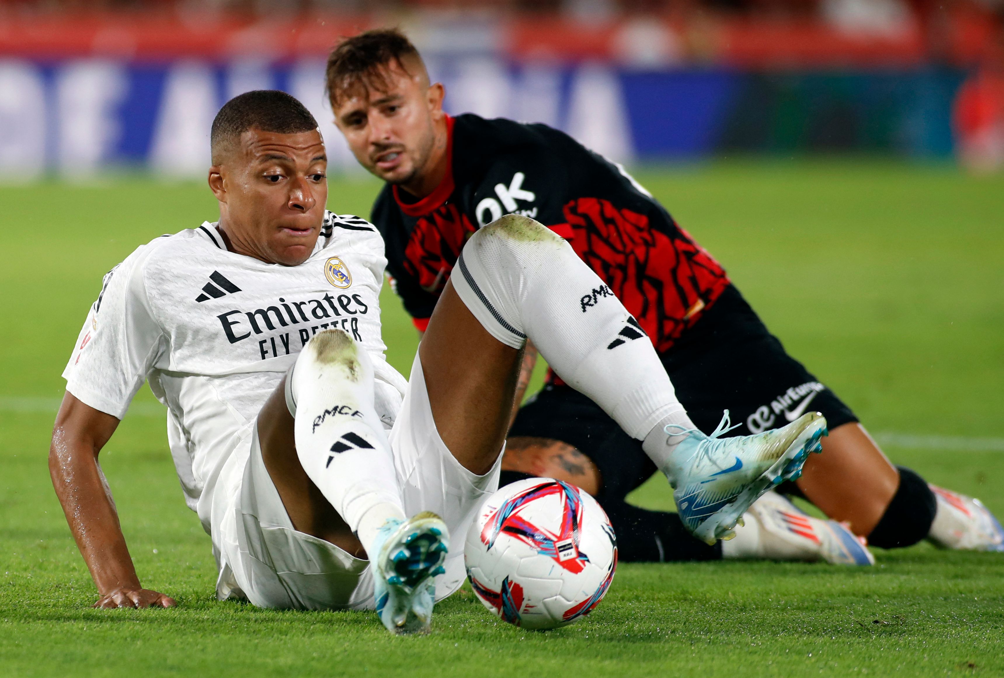 Real Madrid's French forward #9 Kylian Mbappe vies for the ball with Real Mallorca�s Spanish defender #23 Pablo Maffeo during the Spanish league football match between RCD Mallorca and Real Madrid CF at the Mallorca Son Moix stadium in Palma de Mallorca on August 18, 2024. (Photo by JAIME REINA / AFP)