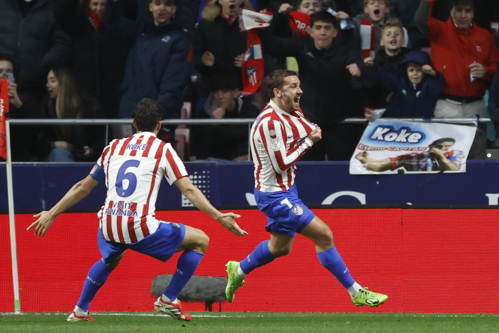 Griezmann celebra su gol mostrando el escudo del Atlético.