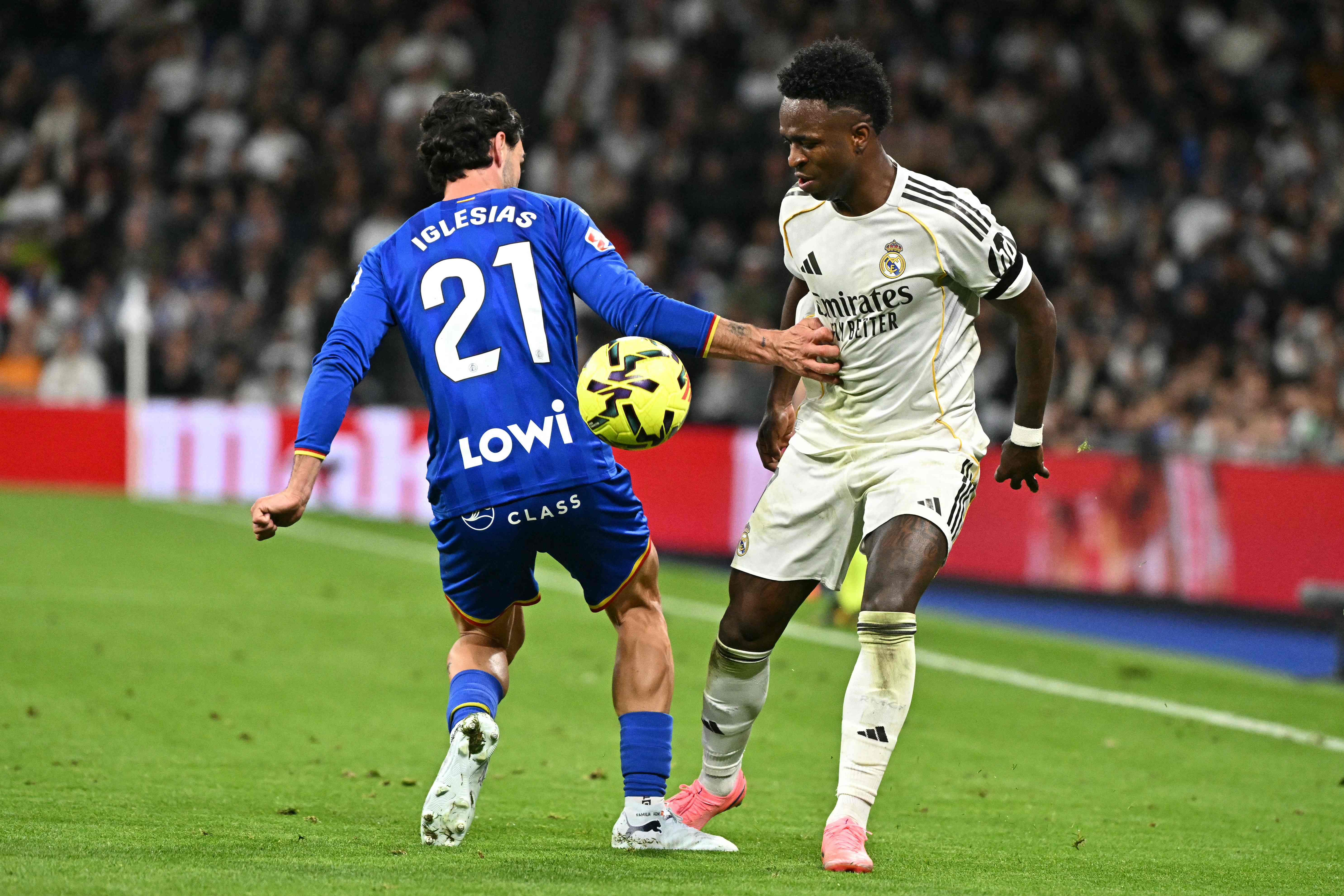 Getafe's Spanish defender #21 Juan Iglesias and Real Madrid's Brazilian forward #07 Vinicius Junior fight for the ball during the Spanish league football match between Real Madrid CF and Getafe CF at Santiago Bernabeu Stadium in Madrid on March 2, 2026. (Photo by Javier SORIANO / AFP)