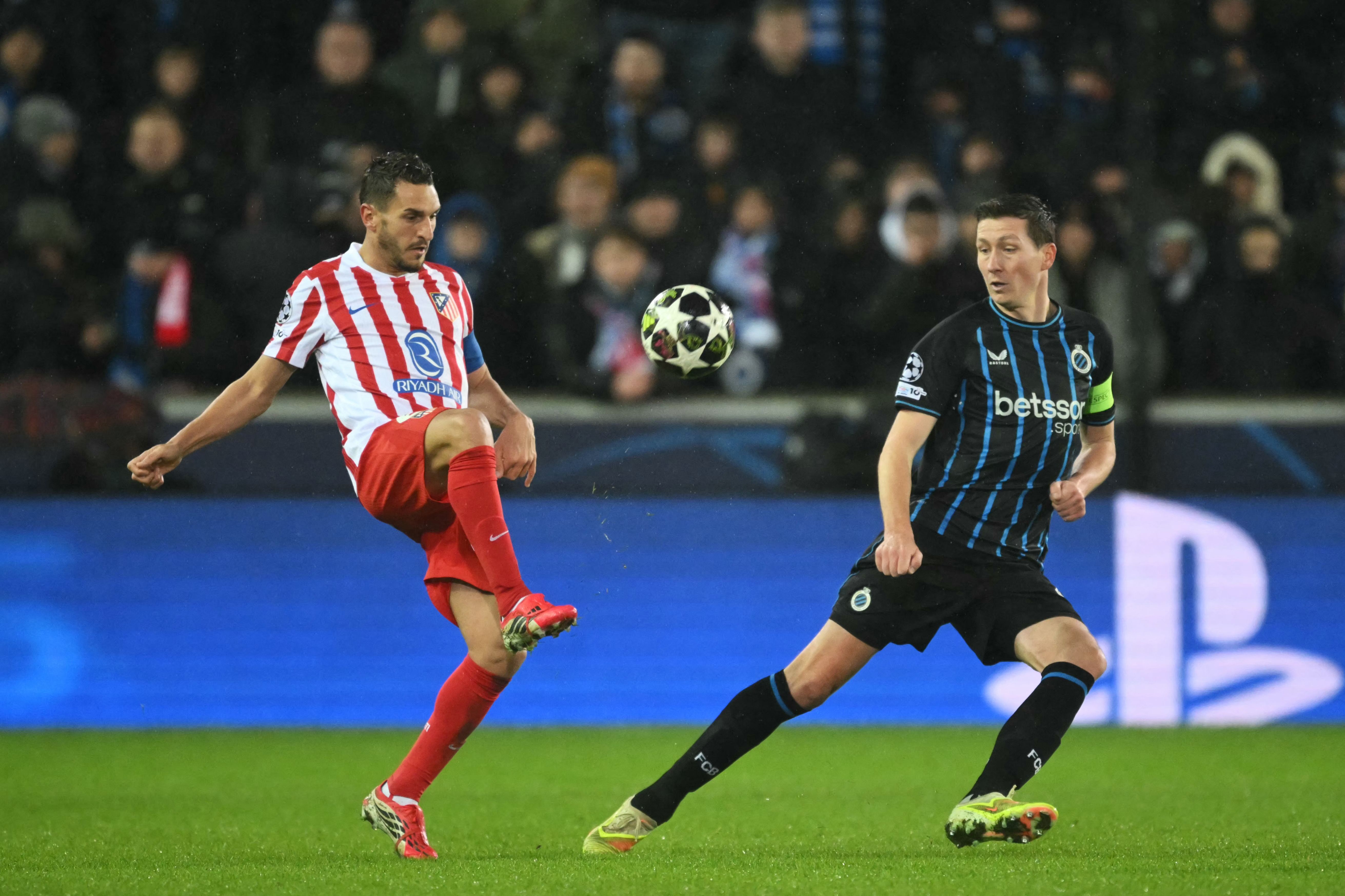 Atletico Madrid's Spanish midfielder #06 Koke (L)and Club Brugge's Belgian midfielder #20 Hans Vanaken fight for the ballduring the UEFA Champions League knockout round play-off first leg football match between Club Brugge and Atletico Madrid at the Jan Breydel Stadium in Brugge on February 18, 2026. (Photo by NICOLAS TUCAT / AFP)