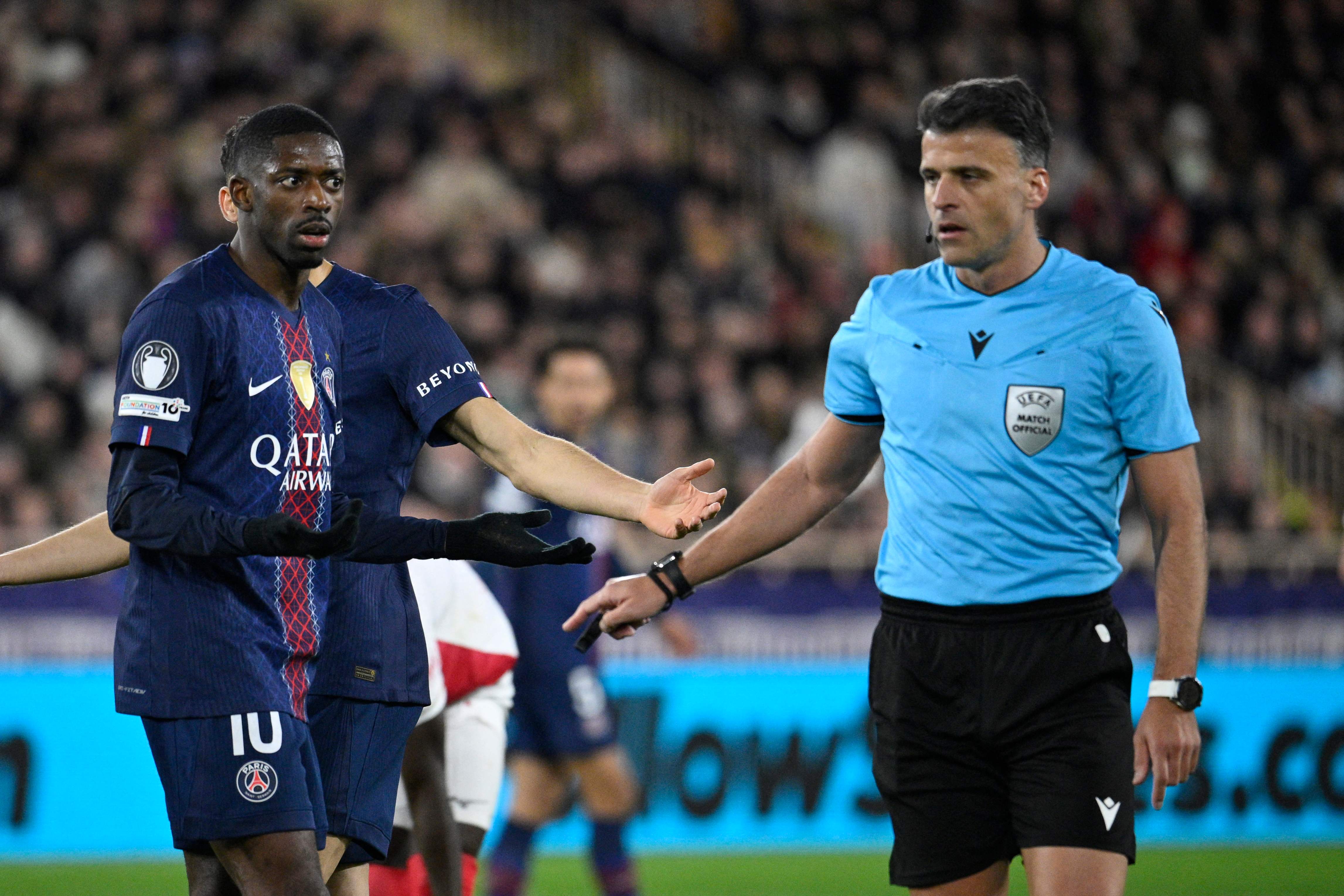 Paris Saint-Germain's French forward #10 Ousmane Dembele reacts to a decision by Spanish referee Jesus Gil Manzano during the UEFA Champions League knockout round play-off first leg football match between AS Monaco and Paris Saint-Germain at the Stade Louis II in the Principality of Monaco on February 17, 2026. (Photo by FREDERIC DIDES / AFP)