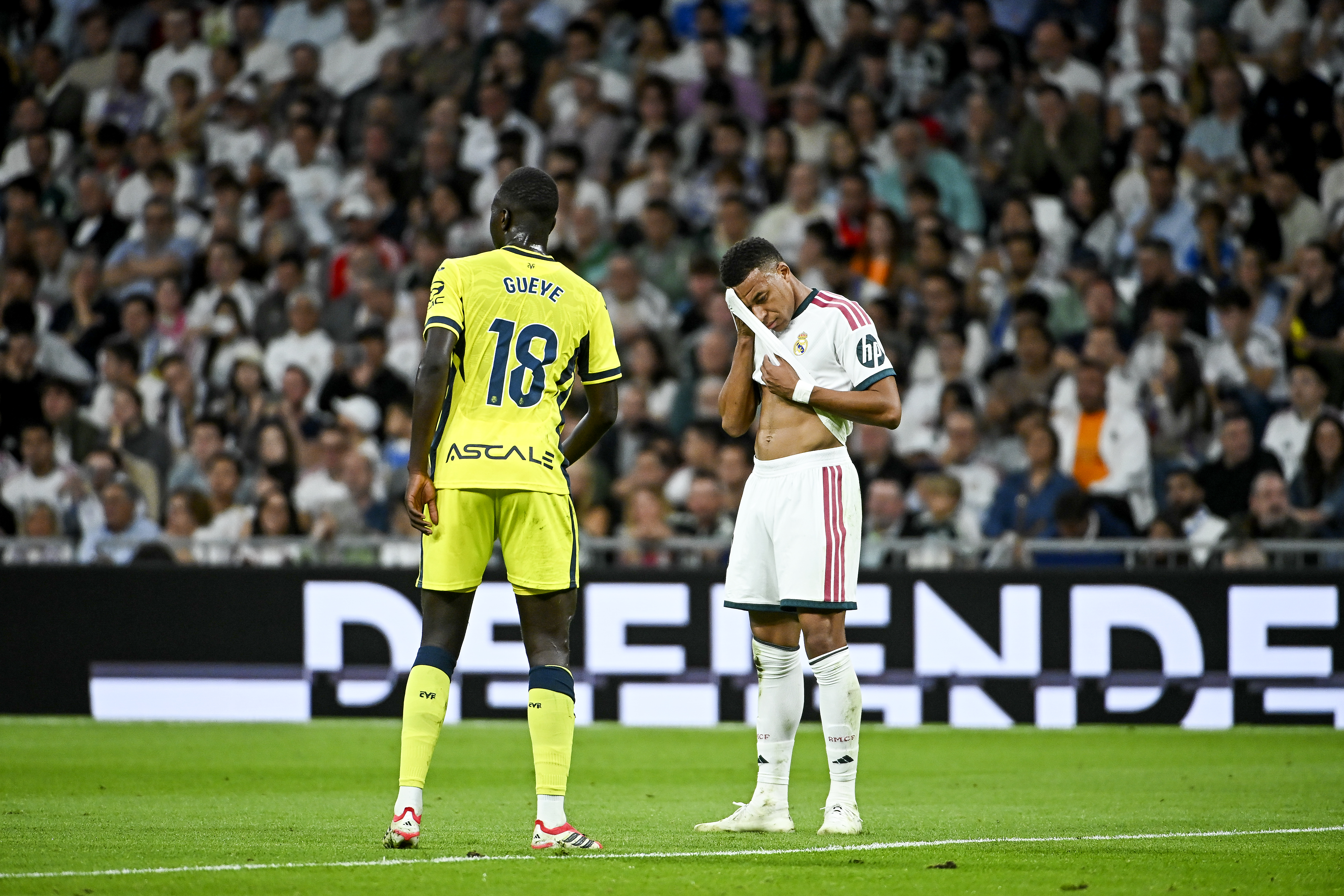 MADRID, 10/10/2026.- El delantero del Real Madrid Kylian Mbappé (d) se seca el sudor ante el centrocampista Pape Alassane Gueye (i), del Villarreal CF, durante el partido de LaLiga de fútbol que Real Madrid y Villarreal CF disputan este sábado en el estadio Santiago Bernabéu. EFE/Fernando Villar 