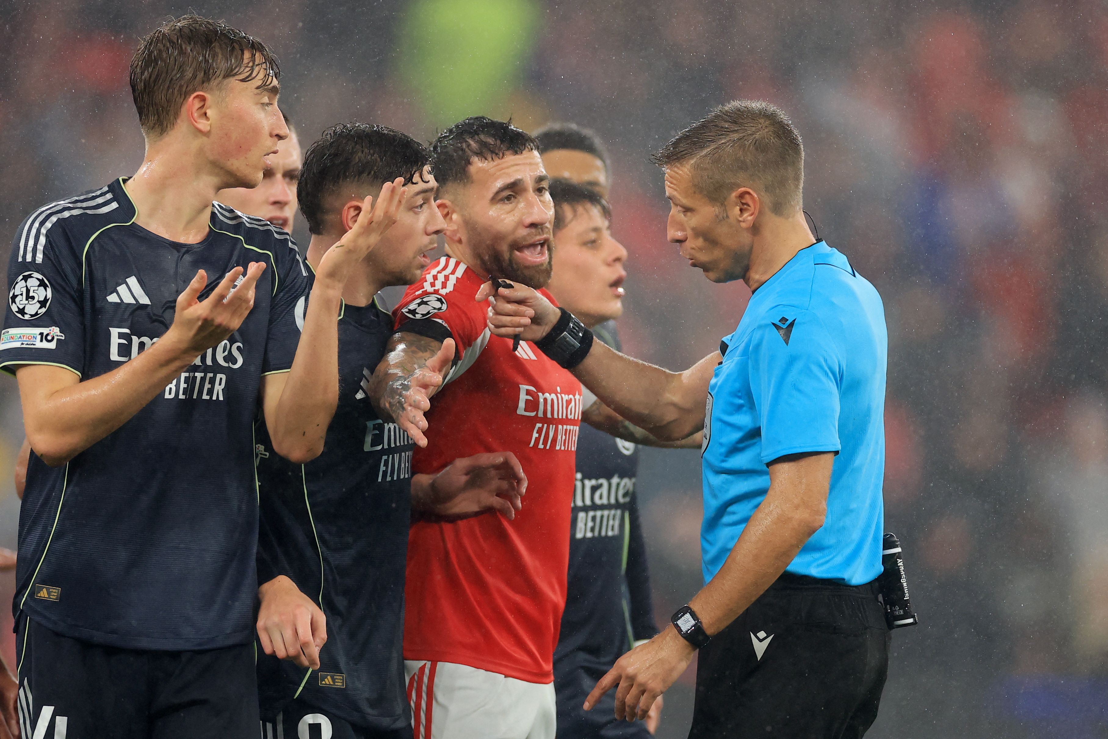 (L-R) Real Madrid's Spanish defender #24 Dean Huijsen, Uruguayan midfielder #08 Federico Valverde and Benfica's Argentine defender #30 Nicolas Otamendi speak with Italian referee Davide Massa during the UEFA Champions League league phase day 8 football match between SL Benfica and Real Madrid CF at Estadio da Luz in Lisbon on January 28, 2026. (Photo by PATRICIA DE MELO MOREIRA / AFP)