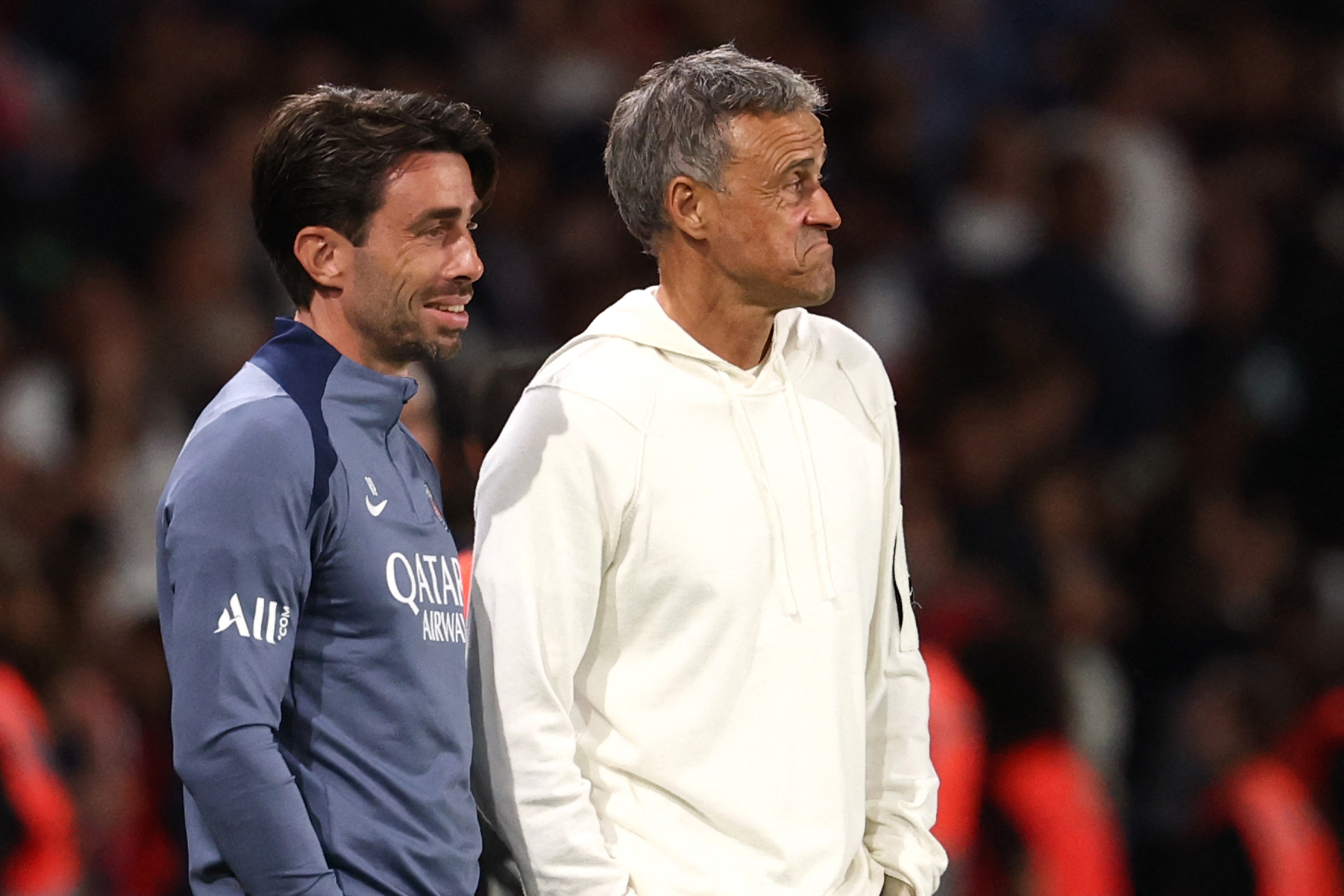 Paris Saint-Germain's Spanish headcoach Luis Enrique and Paris Saint-Germain's Spanish deputy coach Rafel Pol Cabanellas (L) react after the French L1 football match between Paris Saint-Germain (PSG) and Angers SCO at the Parc des Princes Stadium in Paris on August 22, 2025. (Photo by FRANCK FIFE / AFP)