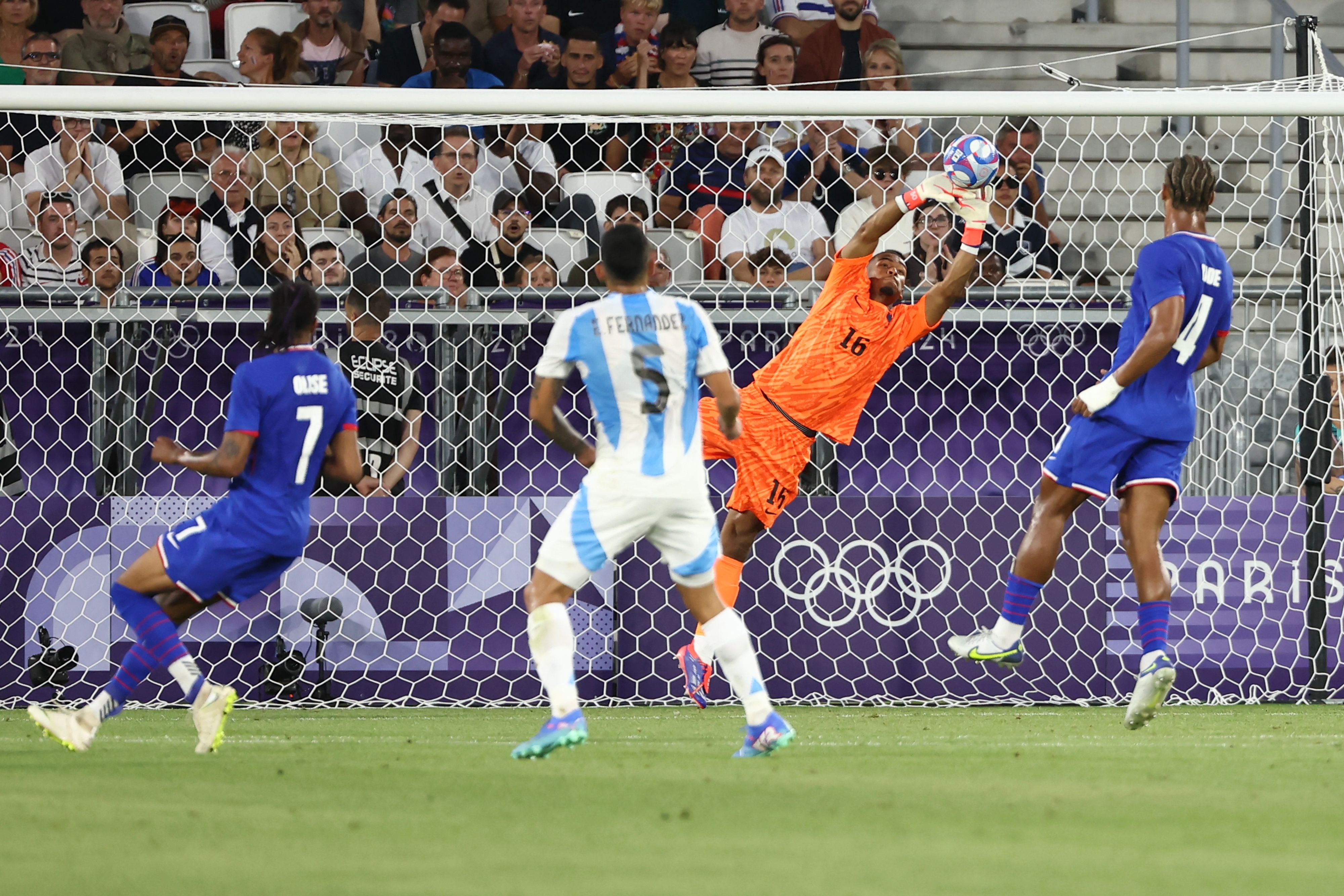France's goalkeeper #16 Guillaume Restes makes a save in the men's quarter-final football match between France and Argentina during the Paris 2024 Olympic Games at the Bordeaux Stadium in Bordeaux on August 2, 2024. (Photo by ROMAIN PERROCHEAU / AFP)