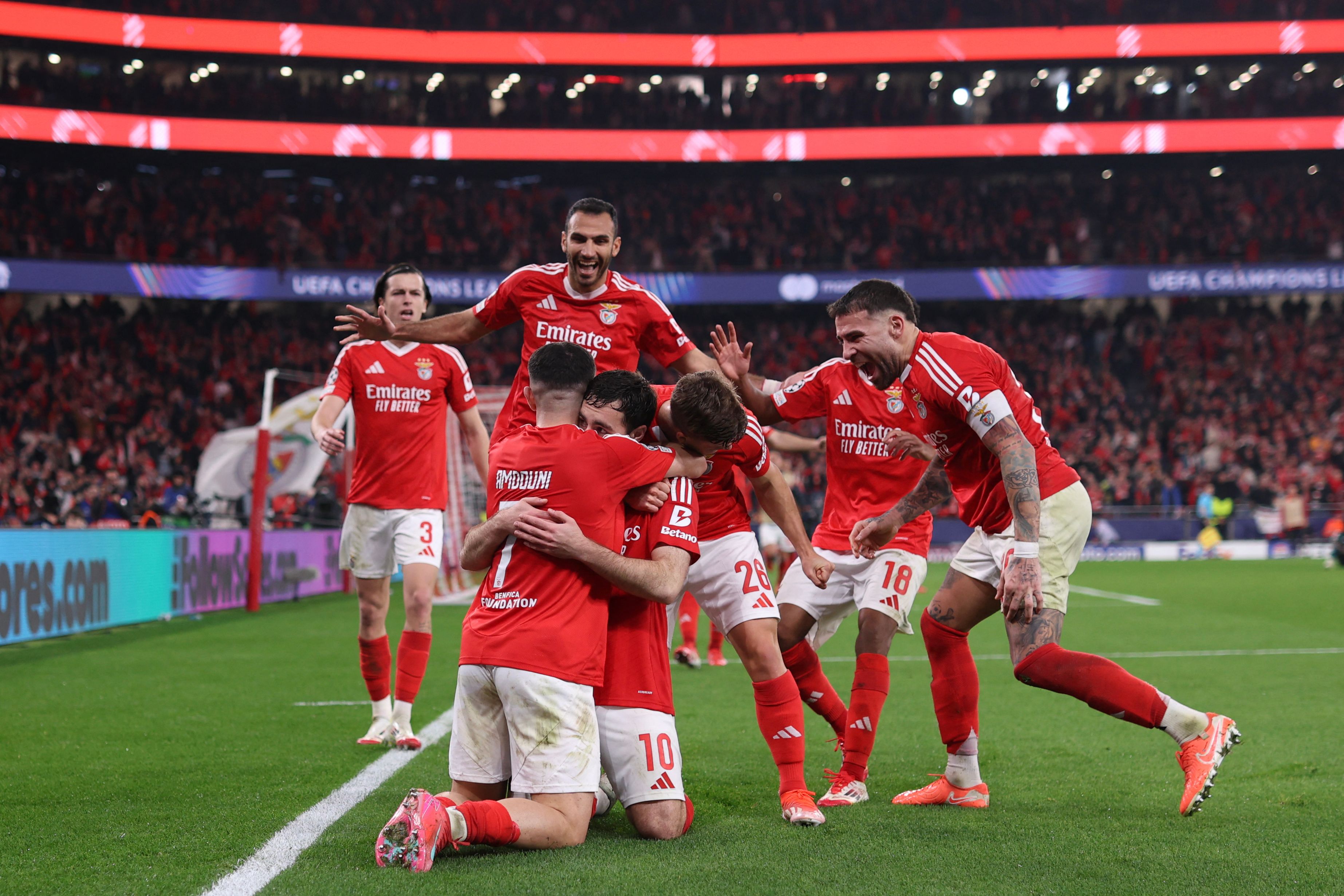 Benfica's Turkish midfielder #10 Orkun Kokcu (C) celebrates with teammates after scoring their third goal during the UEFA Champions League knockout phase play-off second leg football match between SL Benfica and AS Monaco at Luz stadium in Lisbon on February 18, 2025. (Photo by FILIPE AMORIM / AFP)