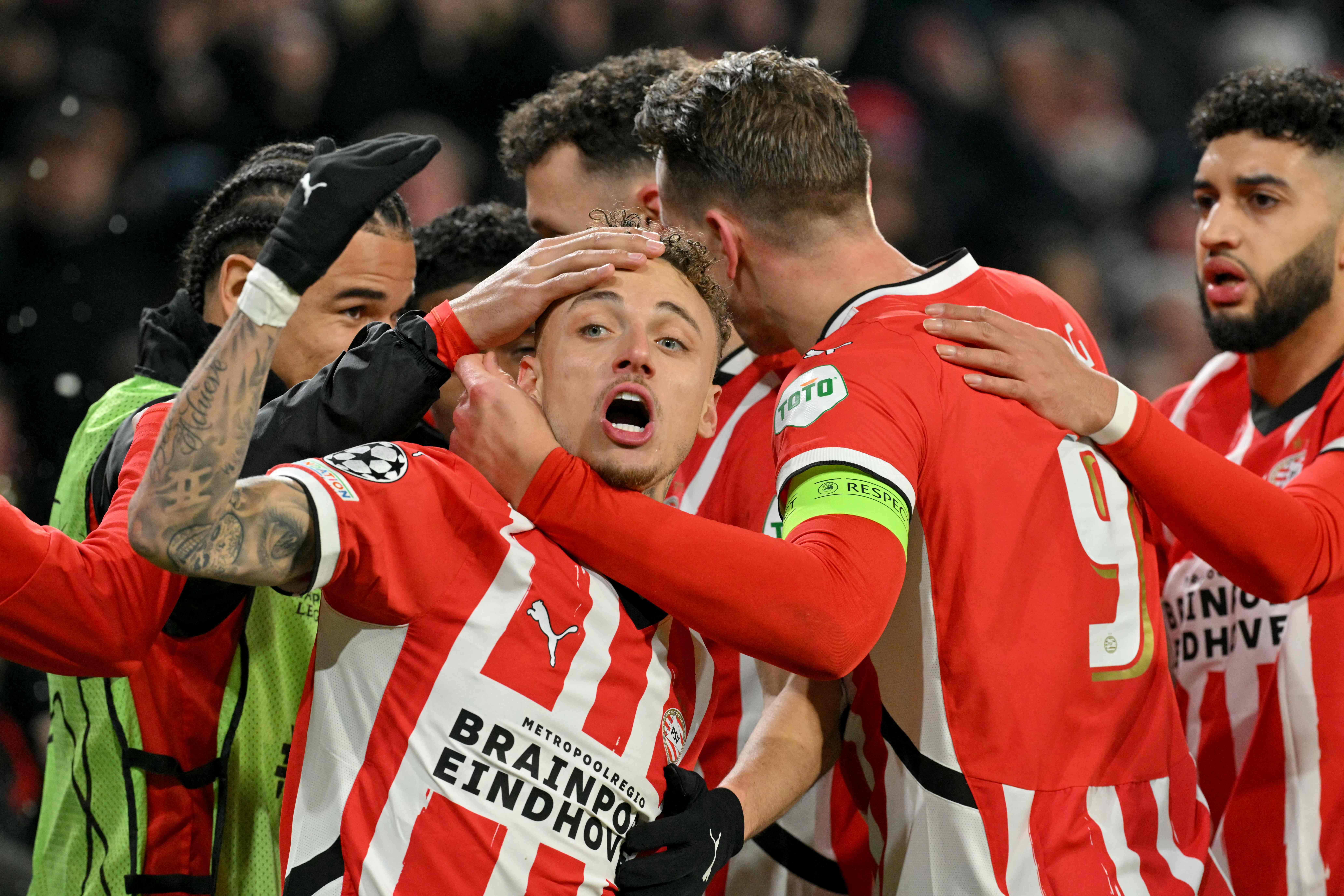 PSV Eindhoven's Dutch forward #10 Noa Lang (C) celebrates his team's first goal with teammates during the UEFA Champions League knockout phase play-off 2nd leg football match between PSV Eindhoven and Juventus at the Philips Stadion in Eindhoven on February 19, 2025. (Photo by NICOLAS TUCAT / AFP)