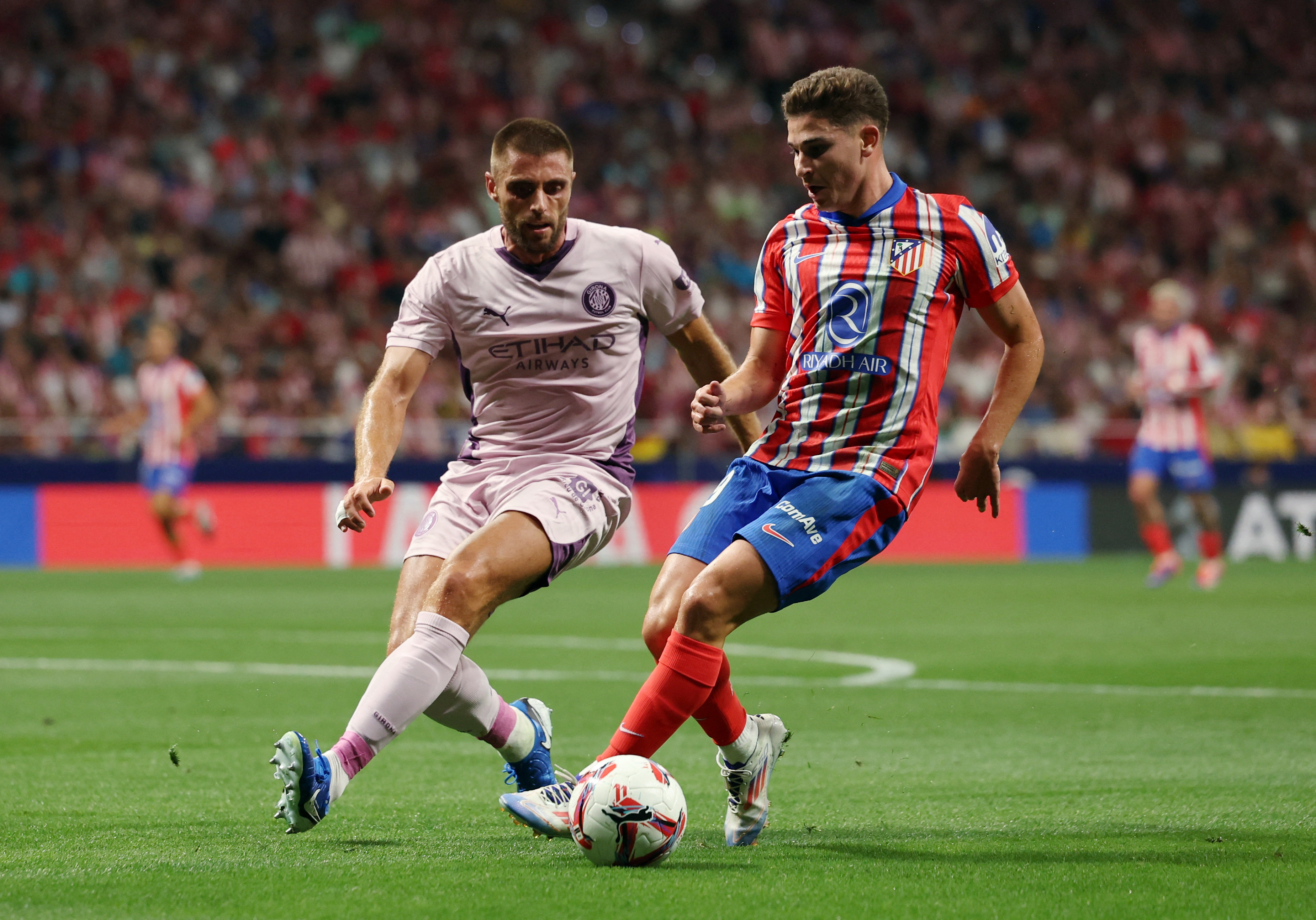 Soccer Football - LaLiga - Atletico Madrid v Girona - Civitas Metropolitano, Madrid, Spain - August 25, 2024 Atletico Madrid's Julian Alvarez in action with Girona's David Lopez REUTERS/Isabel Infantes