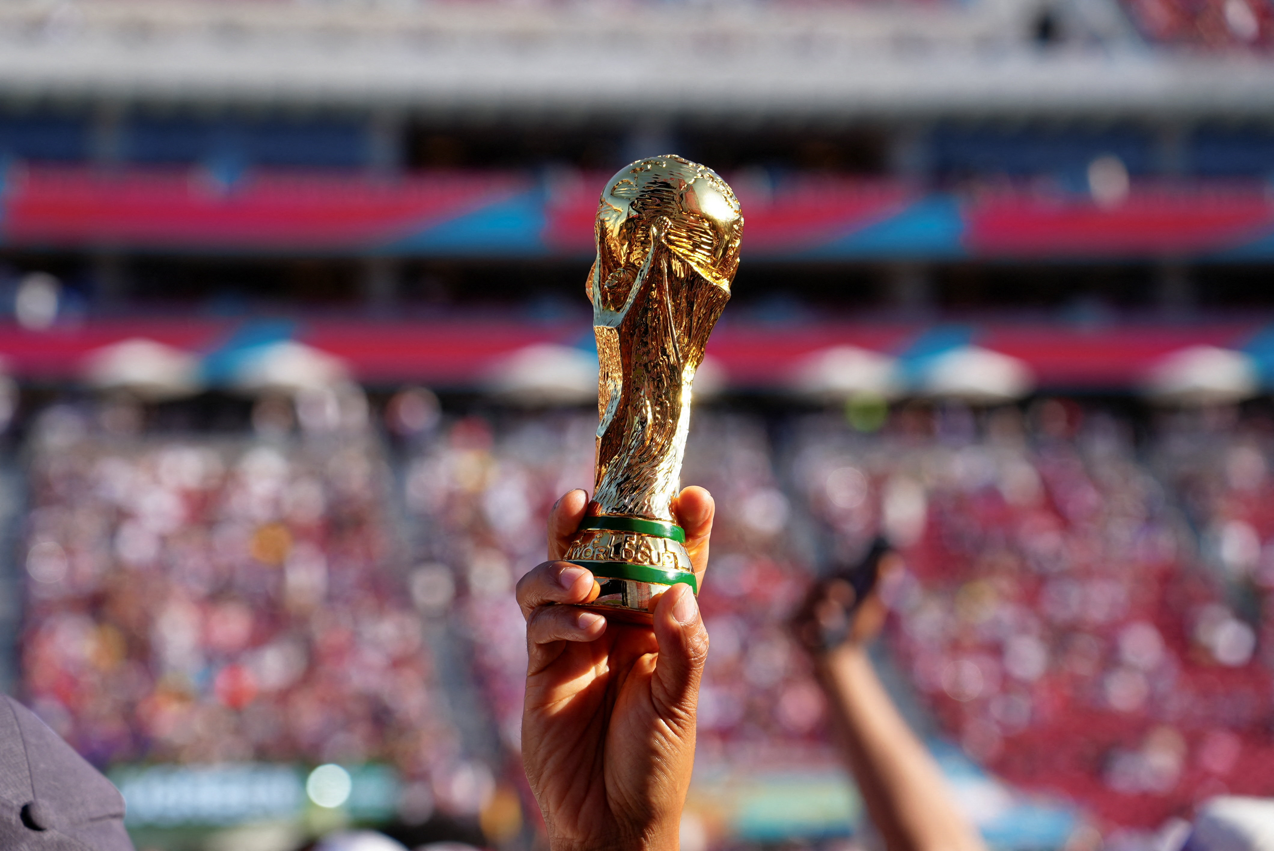 A fan holds a miniature of the FIFA World Cup trophy at the FIFA Fan Festival Los Angeles during FIFA World Cup 2026, at the Los Angeles Memorial Coliseum, California, U.S. June 12, 2026. REUTERS/Arafat Barbakh